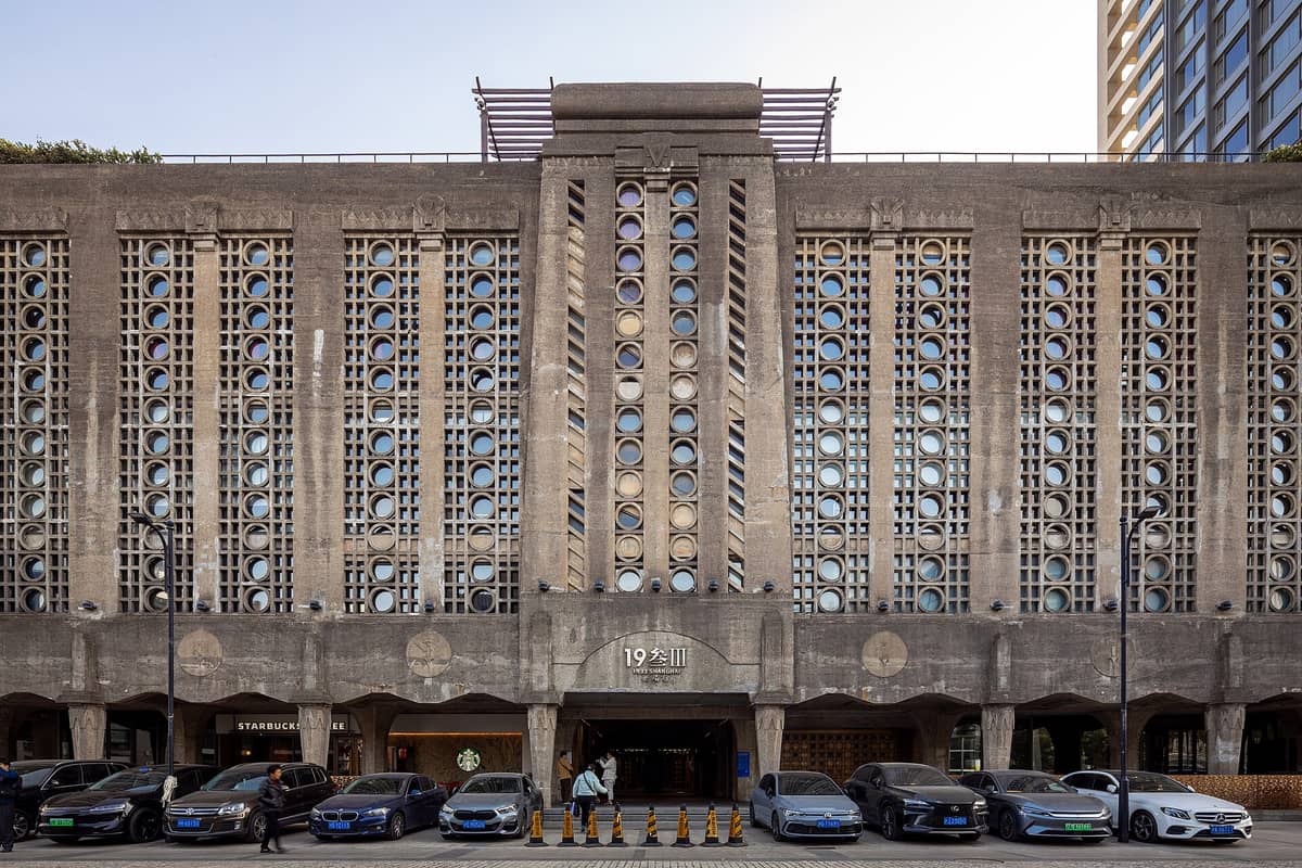Frontfassade des 1933 Old Millfun in Shanghai bei Tageslicht, mit dem markanten Betongitter aus runden und eckigen Fenstern und dem Eingangstor.