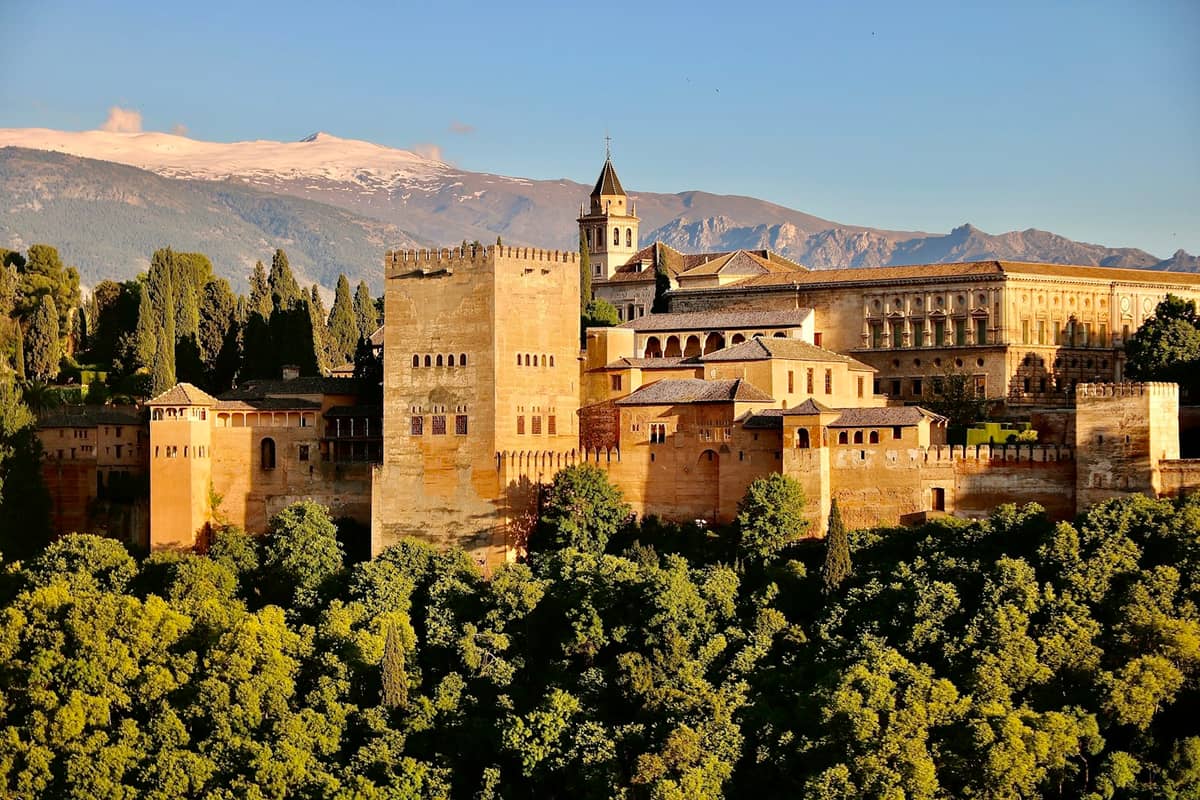 ทิวทัศน์แบบพาโนรามาของกลุ่มอาคาร Alhambra ในเมือง Granada พร้อมหอคอยป้อมปราการอันเป็นสัญลักษณ์และเทือกเขา Sierra Nevada เป็นฉากหลัง