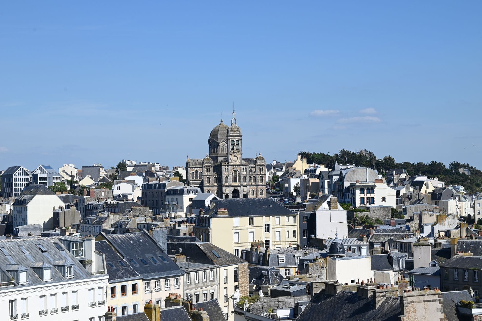 Erhöhte Ansicht des Viertels Sainte-Adresse mit markanter Kirche, Dächern und blauem Himmel in Le Havre.