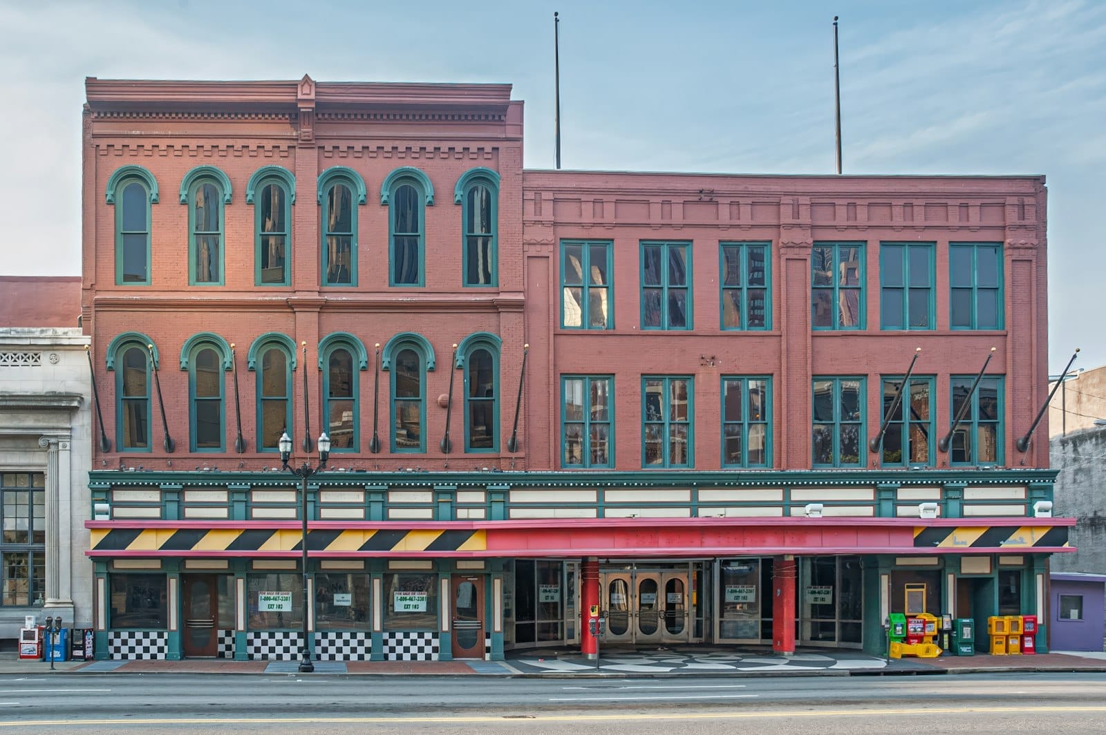 Edificio histórico de ladrillo ornamentado en el centro de Nashville con grandes ventanas arqueadas y toldos coloridos, típico de los famosos locales de música de Broadway.
