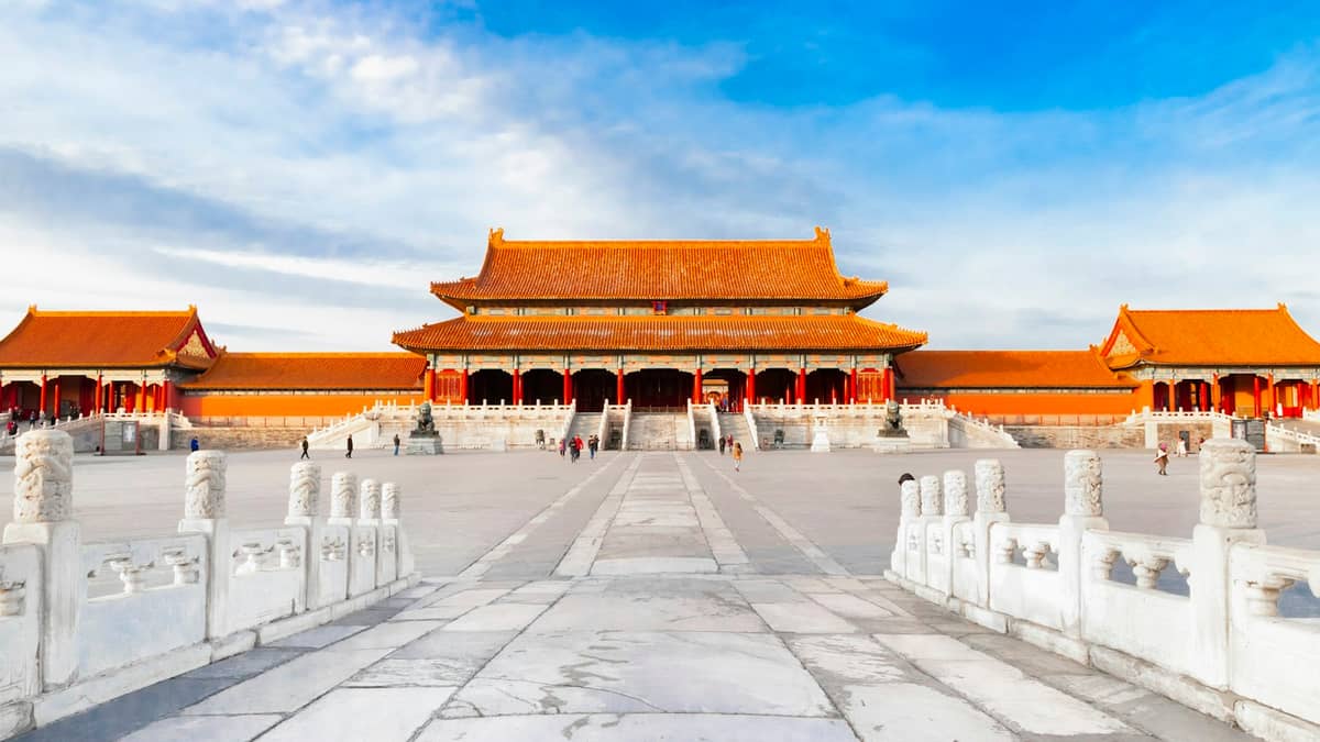 Weitwinkelaufnahme des Haupthofs der Verbotenen Stadt mit der Halle der Höchsten Harmonie unter strahlendem blauem Himmel in Peking.