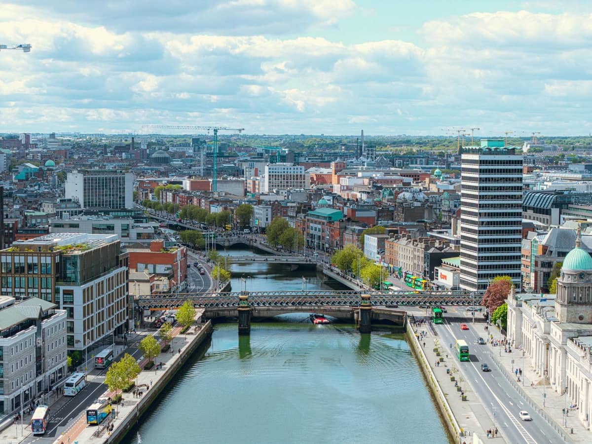 Wyraźny, jasny widok z lotu ptaka na centrum Dublina z rzeką Liffey, mostami i wieloma rozpoznawalnymi budynkami miasta.