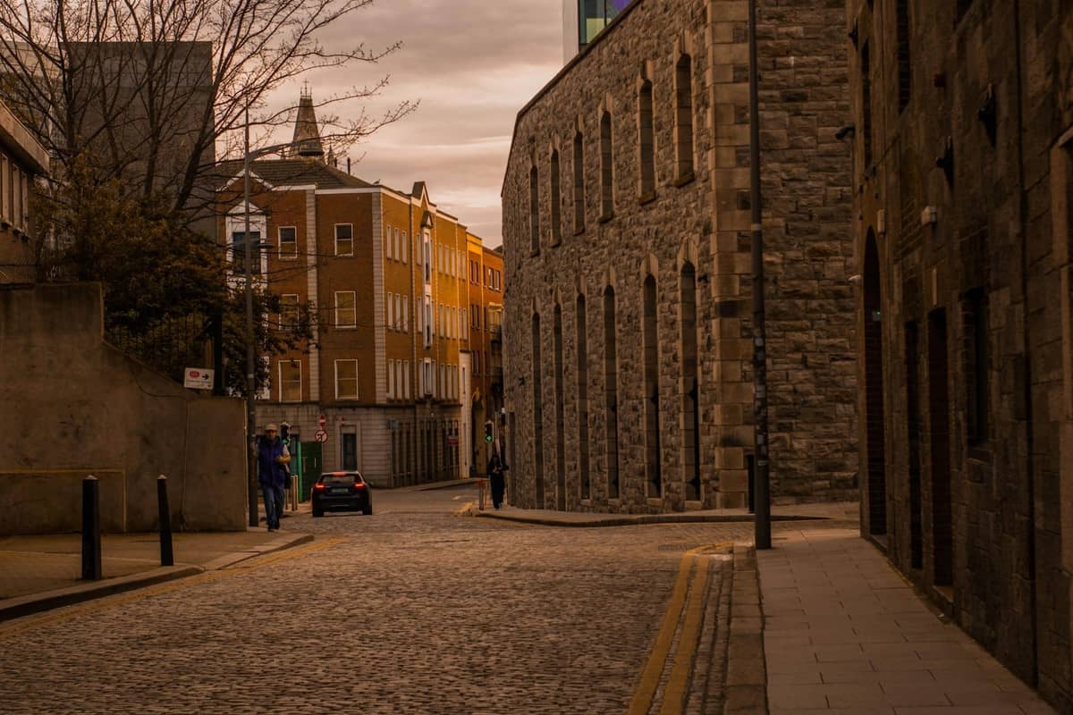 Wąska brukowana uliczka otoczona historycznymi kamiennymi budynkami w Dublinie, oddająca klimat dzielnicy the Liberties.