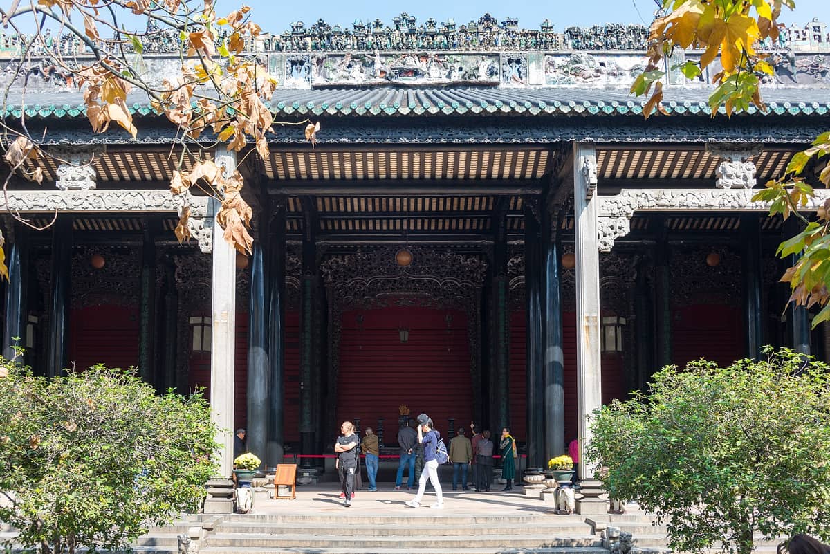 Front view of the Chen Clan Ancestral Hall in Guangzhou, with visitors entering the ornately decorated main entrance and traditional Lingnan architectural details.