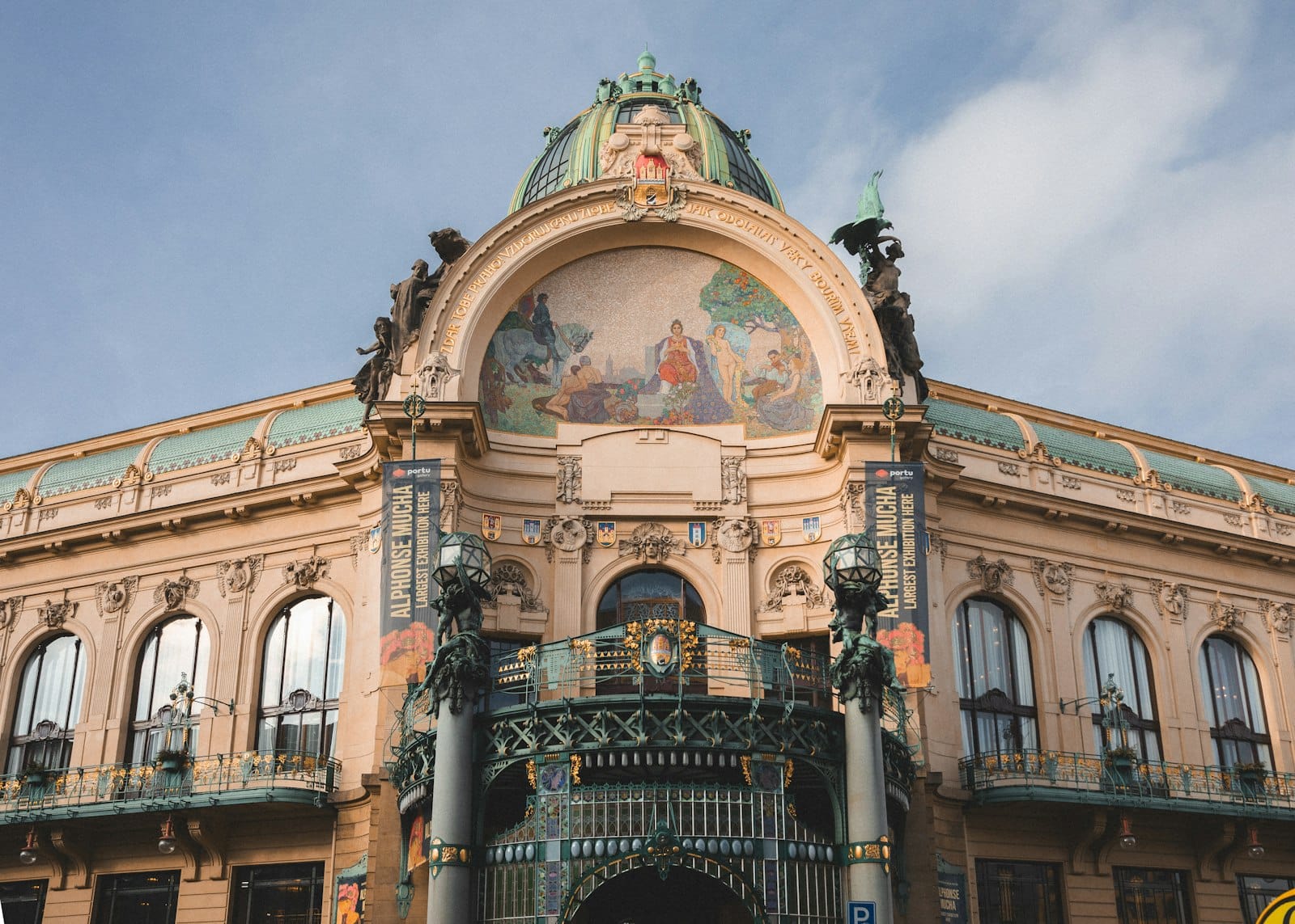 Art Nouveau na harapan ng Municipal House ng Prague na may masalimuot na dekorasyon, bubong na may gumba, at mga bandilang Czech sa maliwanag na araw.