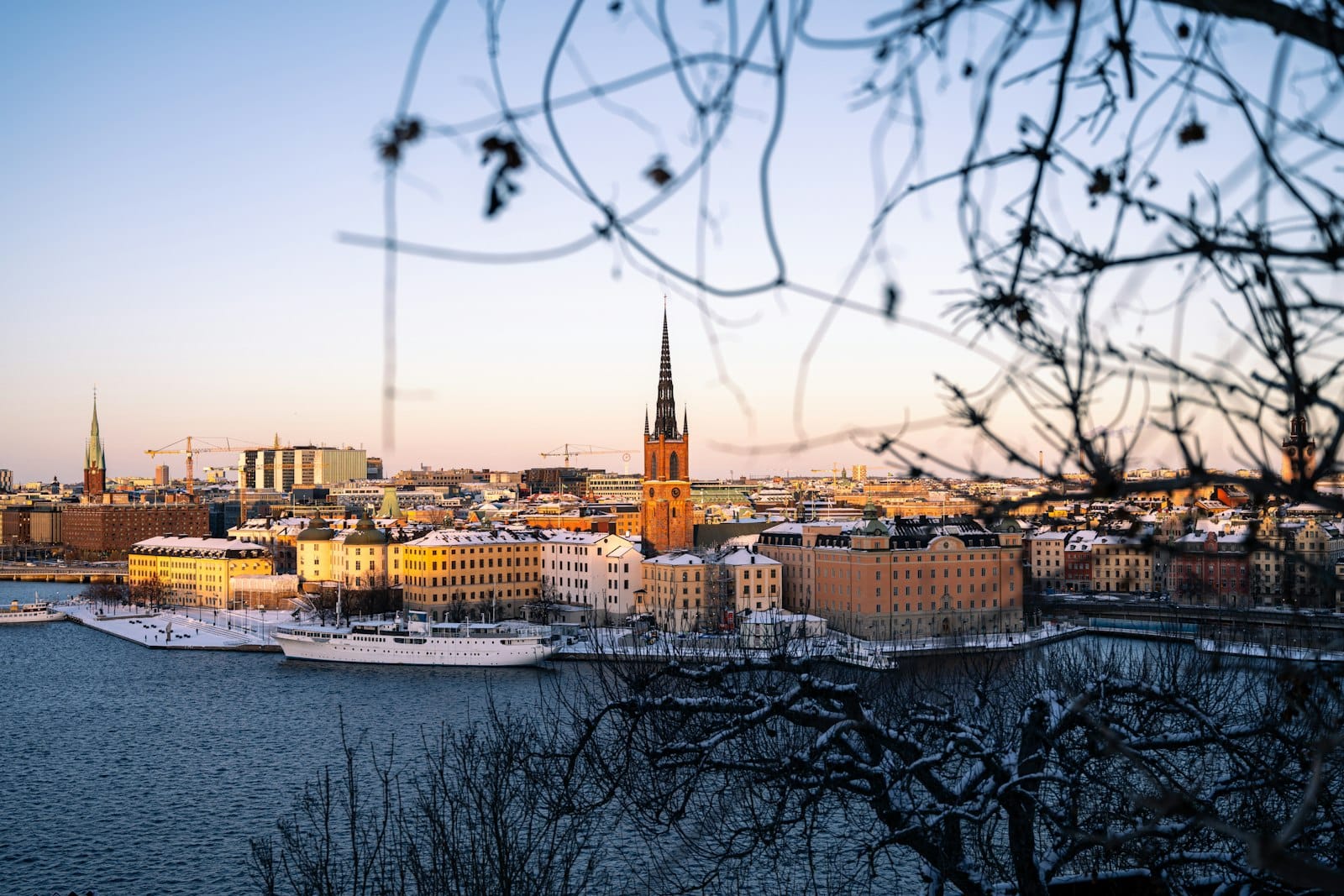 วิวพาโนรามาฤดูหนาวเหนือเมือง Stockholm จากจุดชมวิวสูง โดยมีศาลาว่าการและสถานที่สำคัญอื่นๆ ที่มองเห็นได้เหนือน้ำ