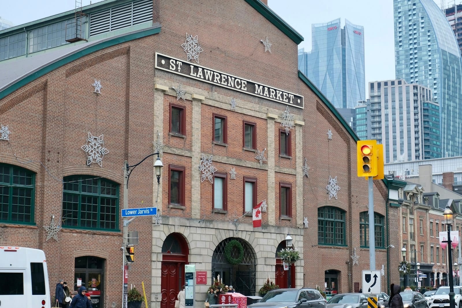 Edifício do St. Lawrence Market em Toronto com fundo urbano e pessoas caminhando pela rua.