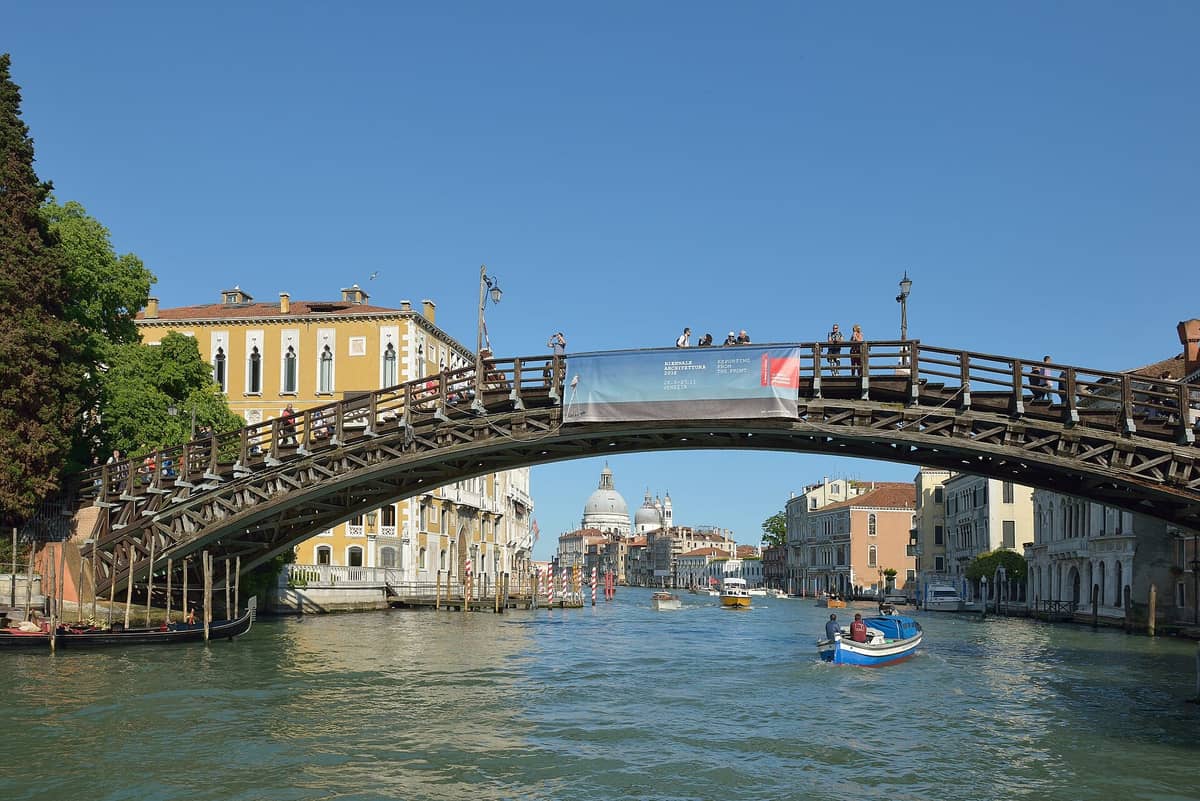 Die Accademia-Brücke, eine hölzerne Fußgängerbrücke über den Canal Grande in Venedig, mit der Kuppel der Santa Maria della Salute im Hintergrund.