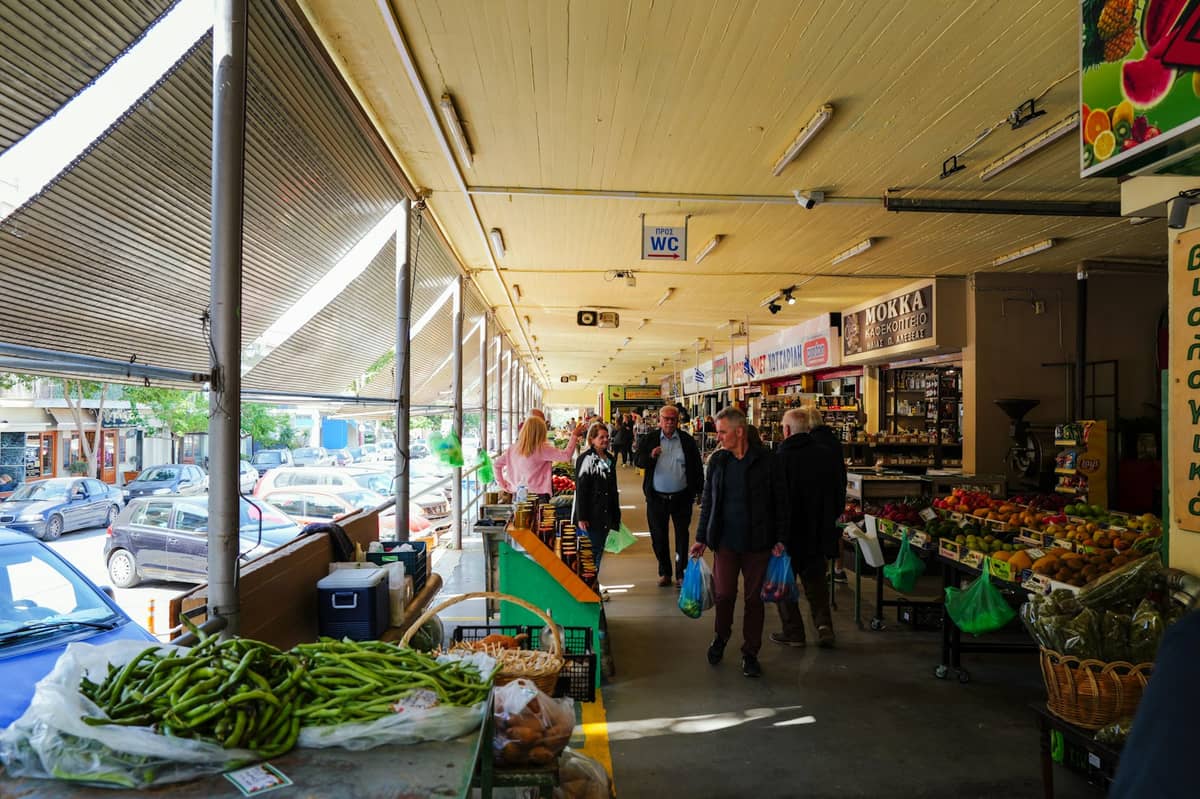 Ludzie spacerujący po targowisku pod gołym niebem ze straganami świeżych warzyw i owoców w Adelaide.