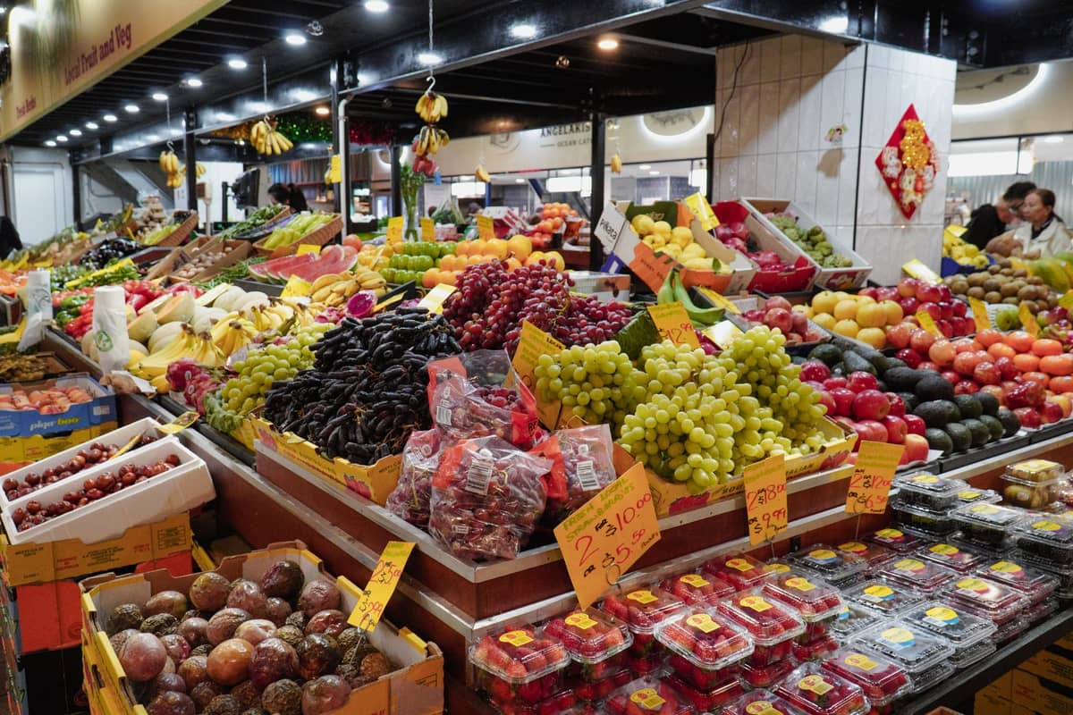 Kolorowe stragany z owocami i warzywami na Adelaide Central Market, pełne produktów i kupujących – jedna z najlepszych budżetowych atrakcji miasta.