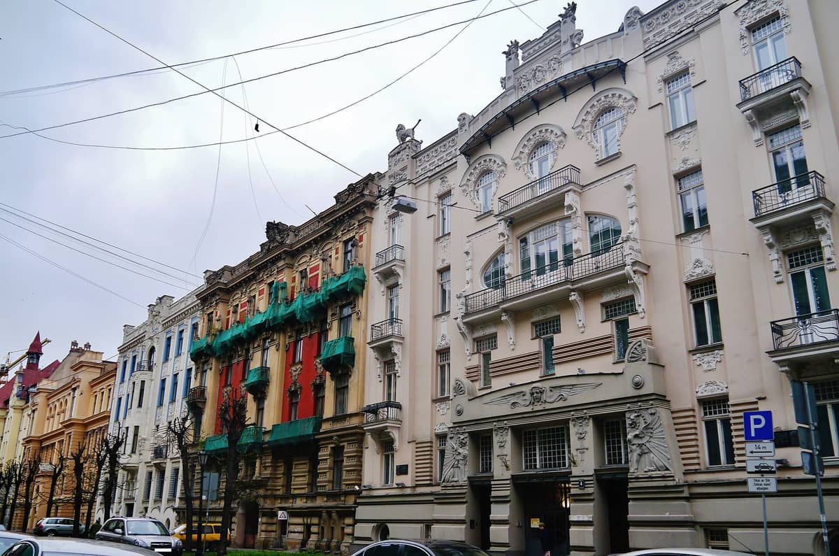 Eine Reihe reich verzierter Jugendstil-Gebäude mit kunstvollen Fassaden und Balkonen entlang der Alberta iela in Riga, Lettland, aus der Straßenperspektive.
