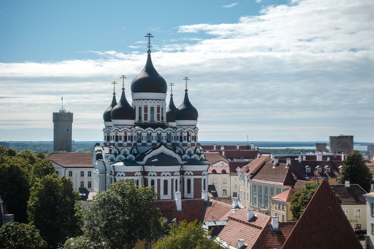Die Alexander-Newski-Kathedrale in Tallinn aus der Vogelperspektive: fünf schwarze Zwiebelkuppeln und eine prächtige Fassade ragen an einem sonnigen Tag über die Dächer der Altstadt.