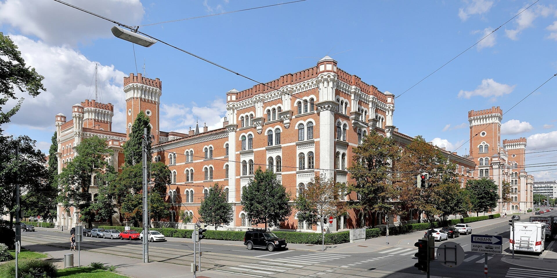 Die Rossauer Kaserne in der Alsergrund, Wien, beeindruckt mit markanter Backsteinarchitektur mit Türmen und Bogenfenstern an einem sonnigen Tag.