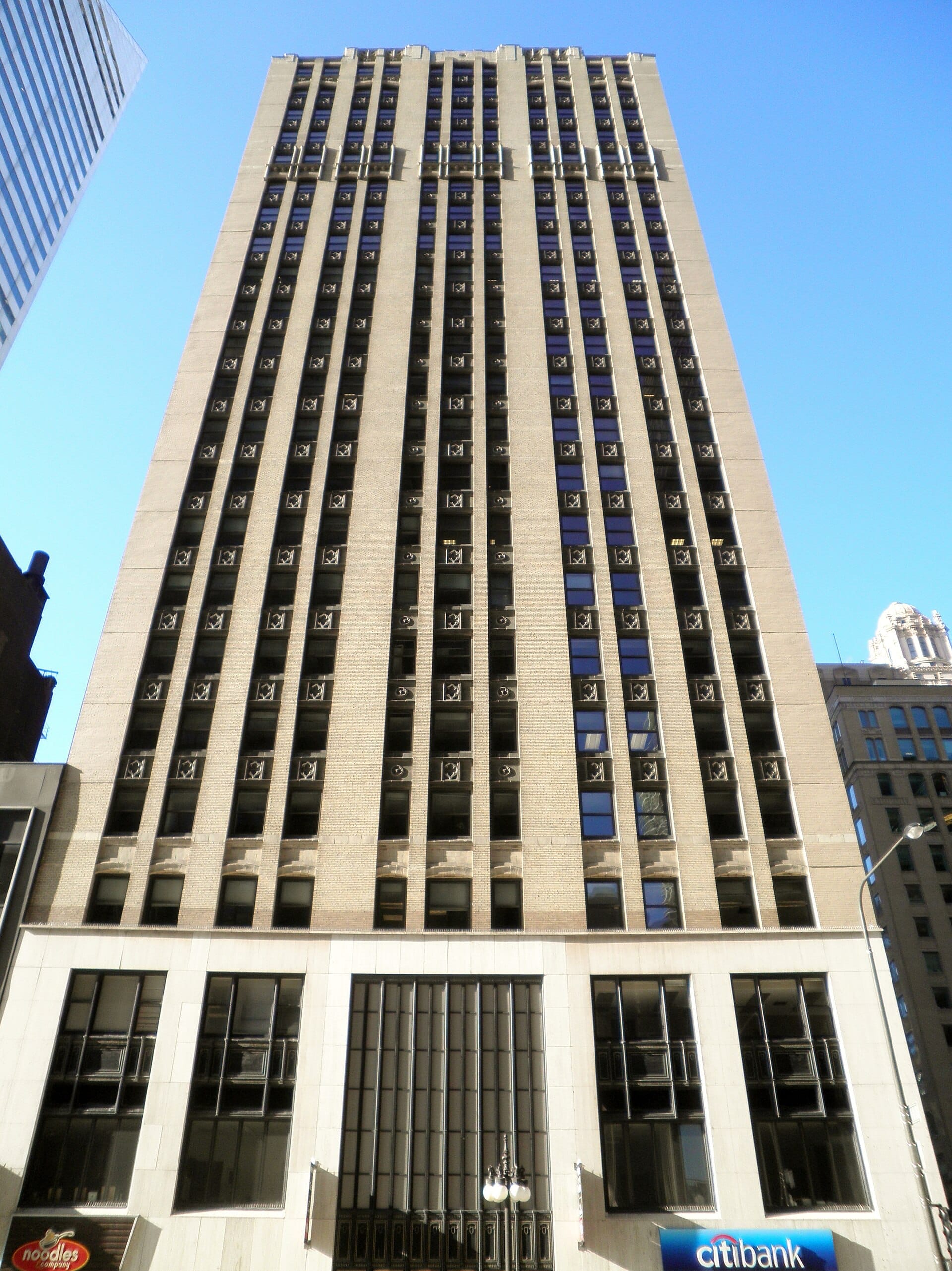 Alto grattacielo beige al 180 N. Michigan Avenue, sede dell'American Writers Museum, con finestre simmetriche su un cielo blu limpido di Chicago.