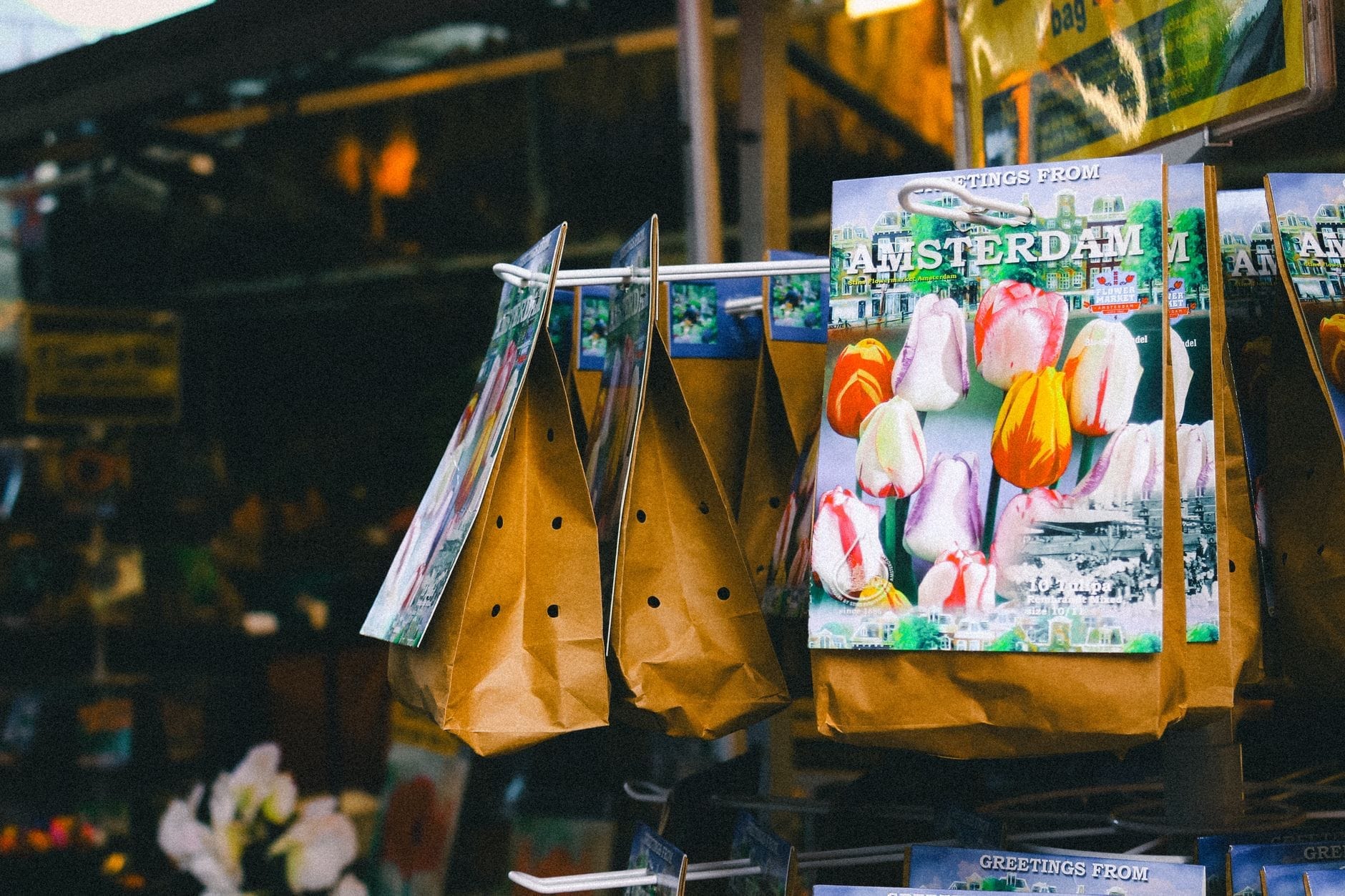 Paquetes de bulbos de tulipán etiquetados Amsterdam a la venta en un puesto de mercado, destacando un típico souvenir holandés.