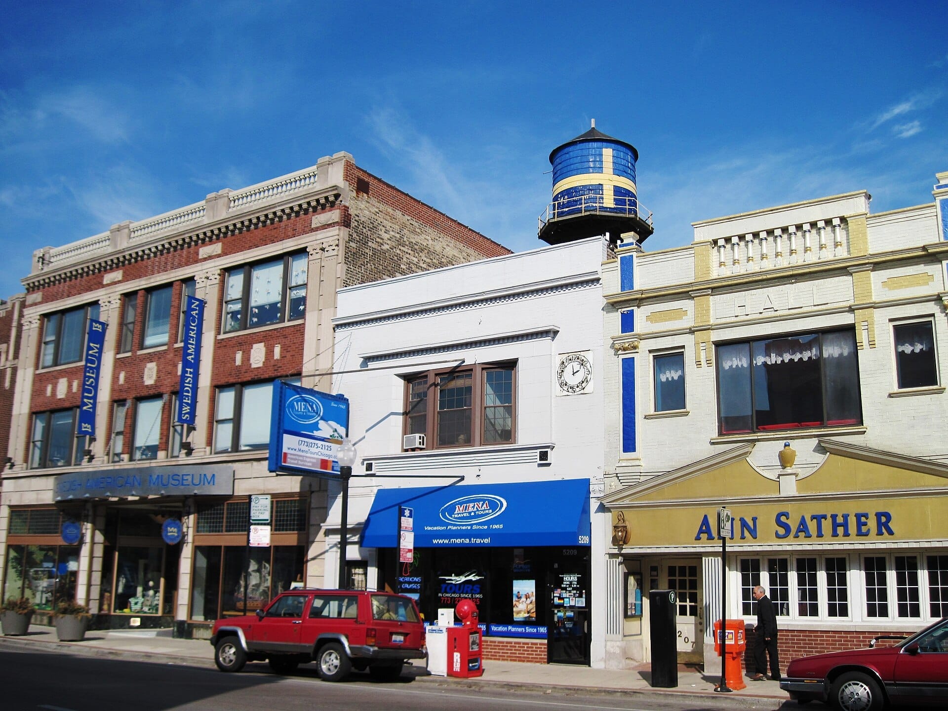 วิวถนน Andersonville สีสันสดใสที่มี Swedish American Museum หอเก็บน้ำสีน้ำเงินและเหลือง และอาคารอิฐประวัติศาสตร์ในวันที่แดดจัด