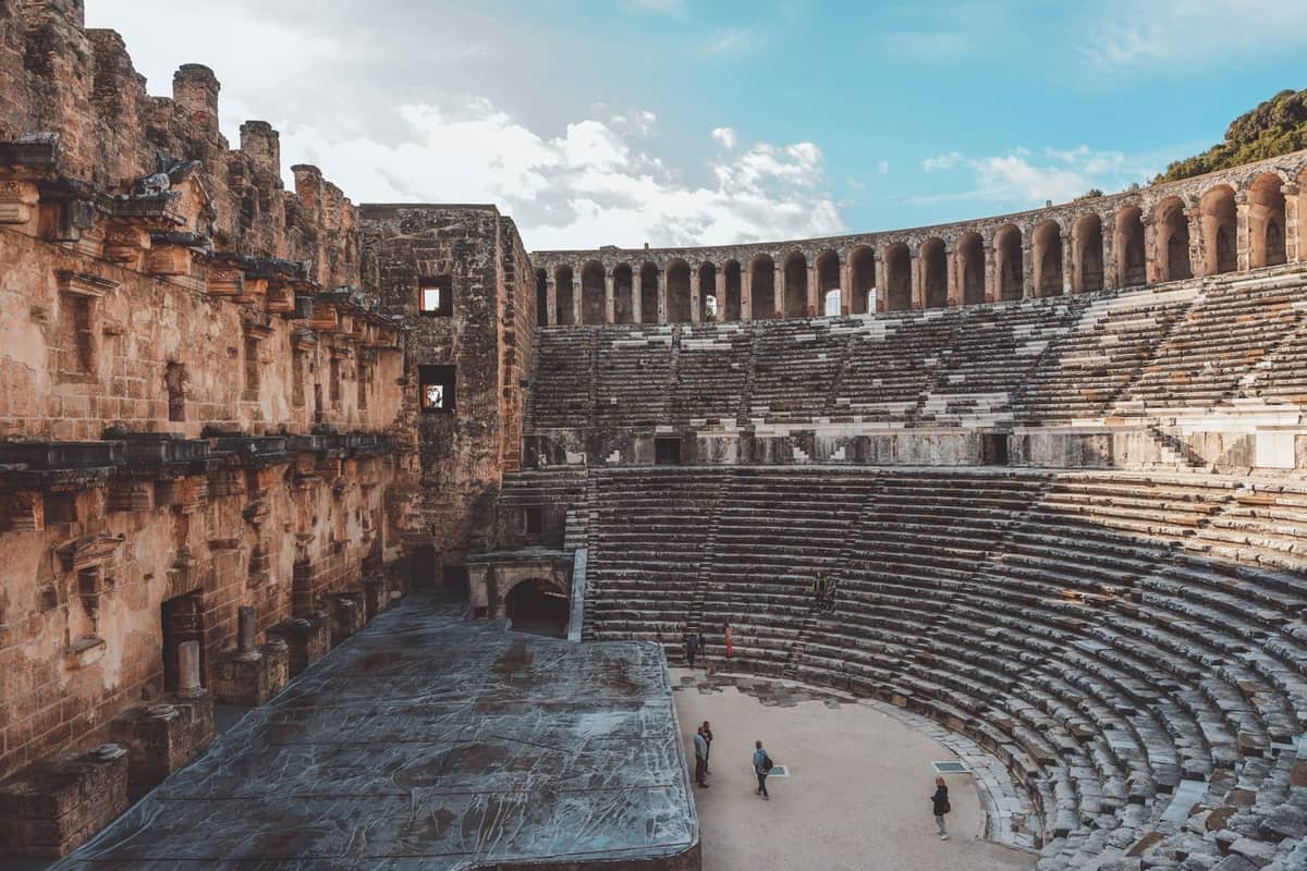 Wide view of the well-preserved ancient Aspendos Roman theater near Antalya, with impressive stone seating and stage under blue sky.