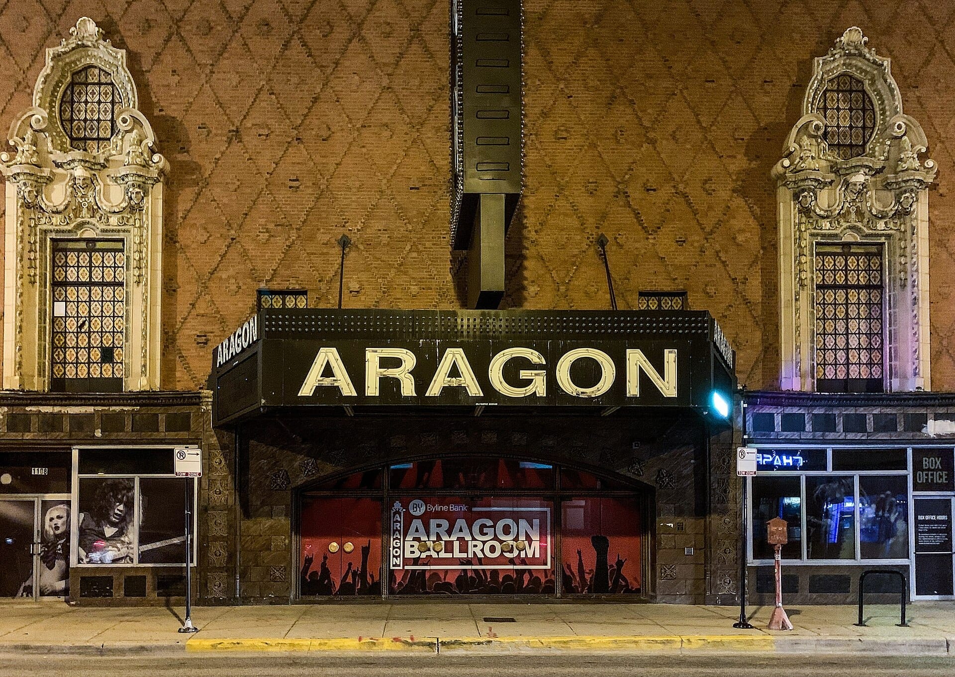 Facciata anteriore dell'Aragon Ballroom a Chicago, con le sue finestre ornate, il mattone decorato e l'insegna luminosa in serata.
