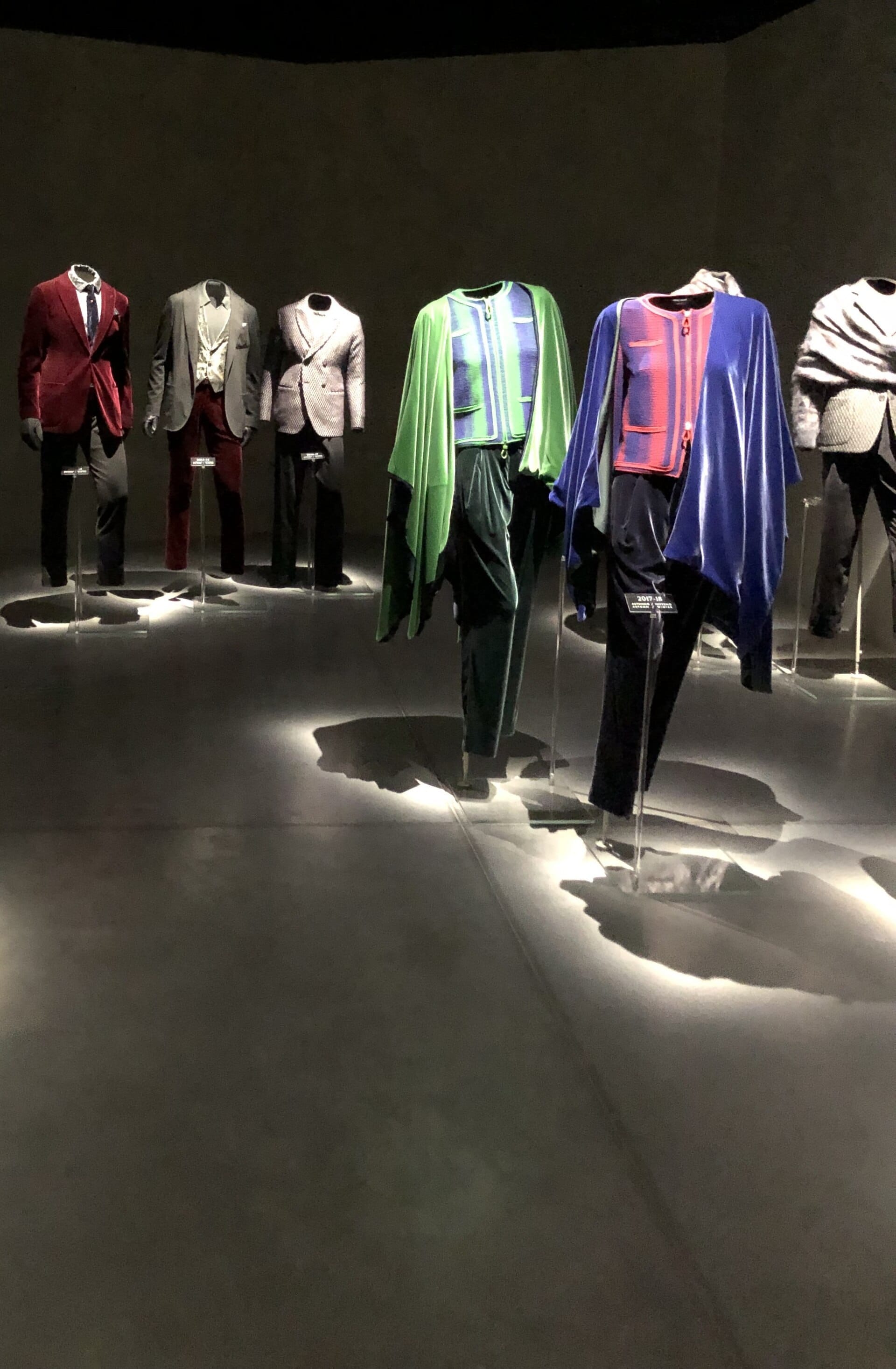 Manichini che espongono i caratteristici abiti e mantelli di Giorgio Armani sotto i riflettori all'interno del museo della moda Armani/Silos, scarsamente illuminato, a Milano.