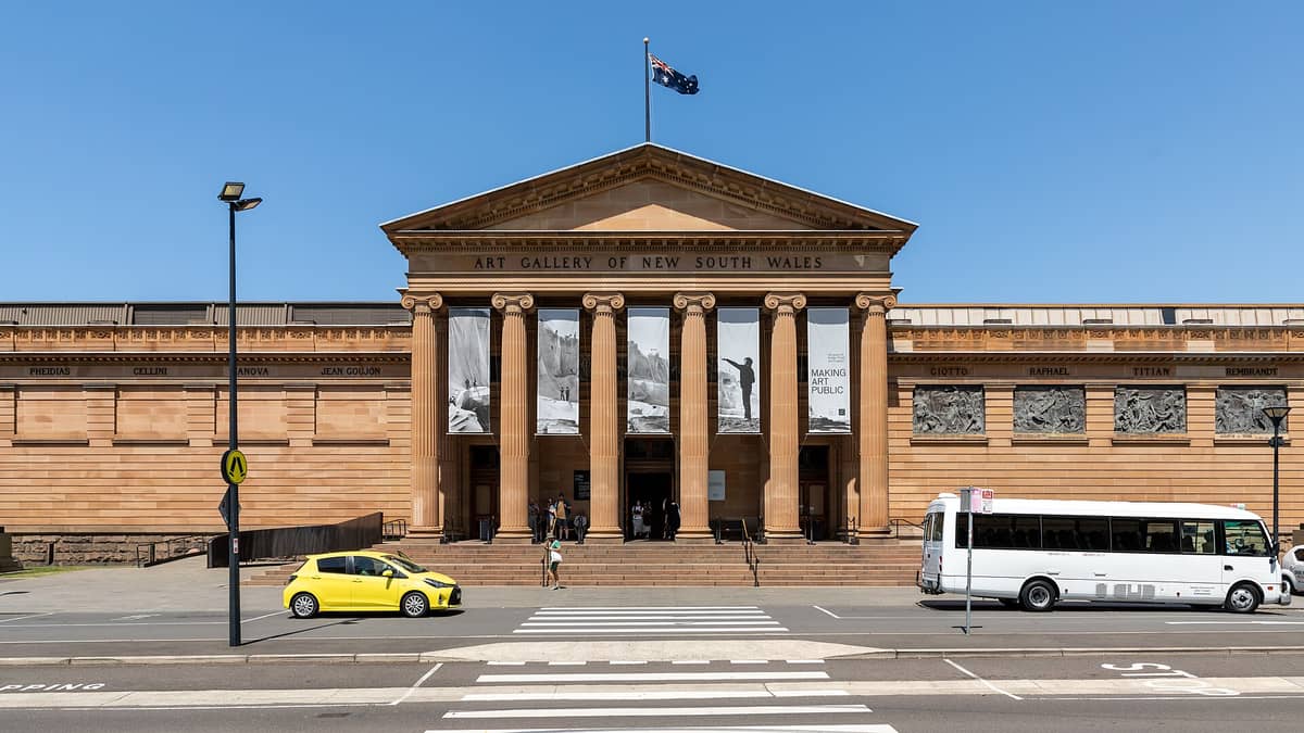 Vista frontale dell'Art Gallery of New South Wales a Sydney, con il grande ingresso a colonne, i banner e i visitatori che entrano.