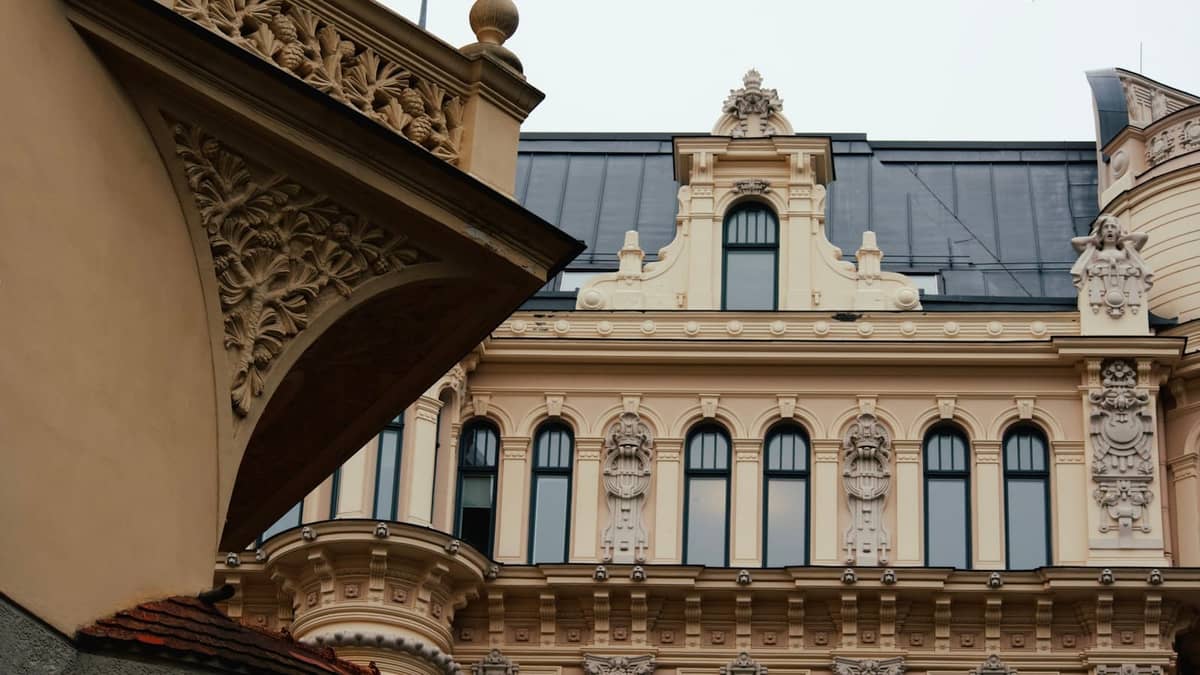 Detailreiche Jugendstil-Fassaden in Riga mit aufwendigem Stuckdekor, Bogenfenstern und ornamentalen Reliefs in hellen Tönen, horizontale Komposition.