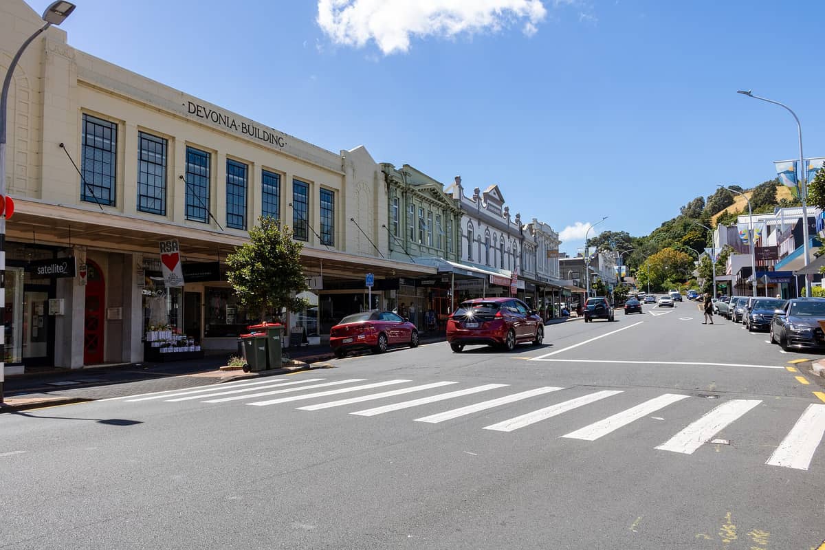 Hauptstraße von Devonport mit historischen Gebäuden, Geschäften, geparkten Autos und einem Fußgängerüberweg an einem sonnigen Tag