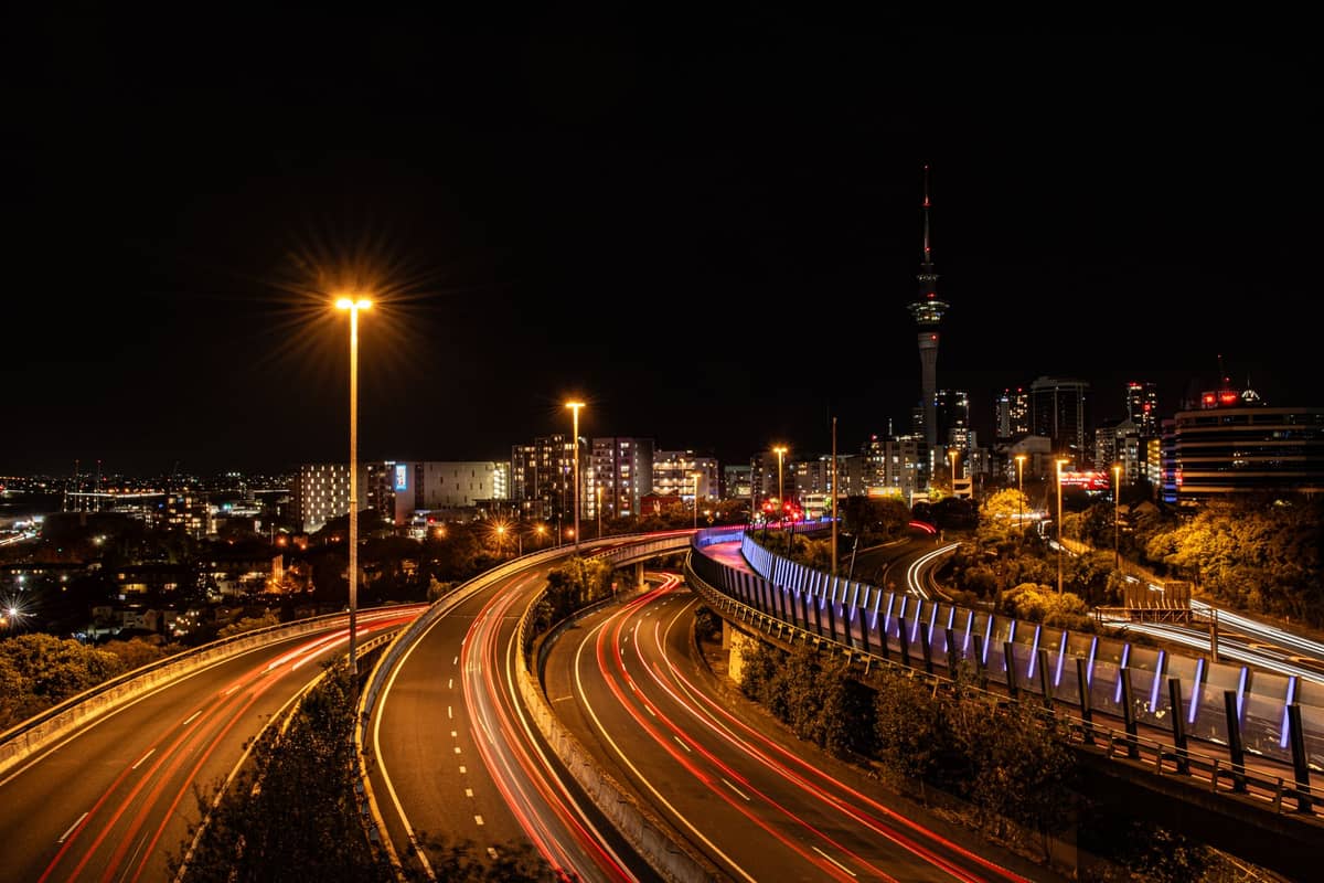 Nächtliche Skyline von Auckland mit dem Sky Tower und beleuchteten Schnellstraßen – die Stadt bei Nacht voller Energie.