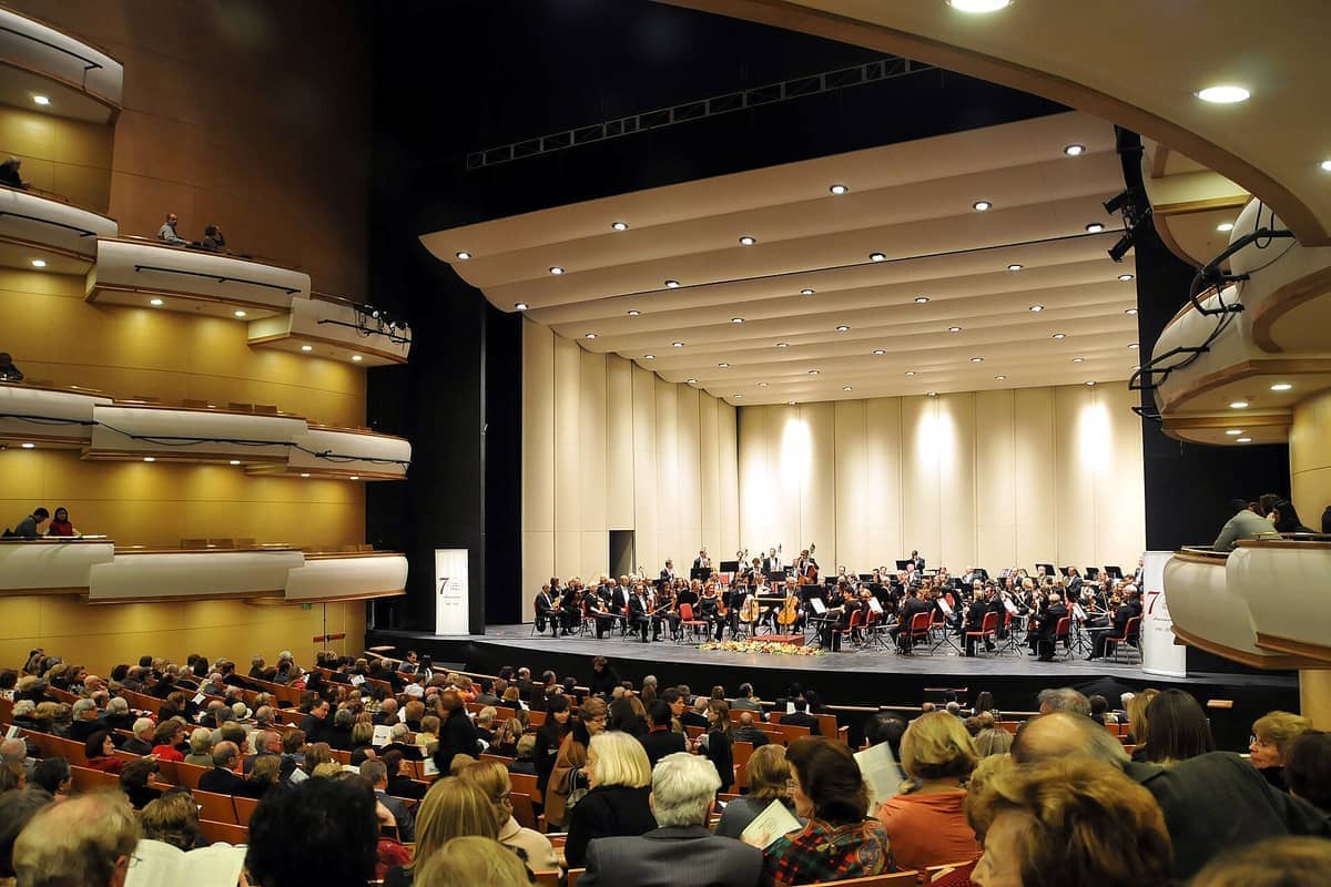 ห้องคอนเสิร์ตหลักของ Auditorio Nacional del SODRE เต็มไปด้วยผู้ชมที่กำลังชมวงออร์เคสตราแสดงบนเวทีที่สว่างไสว