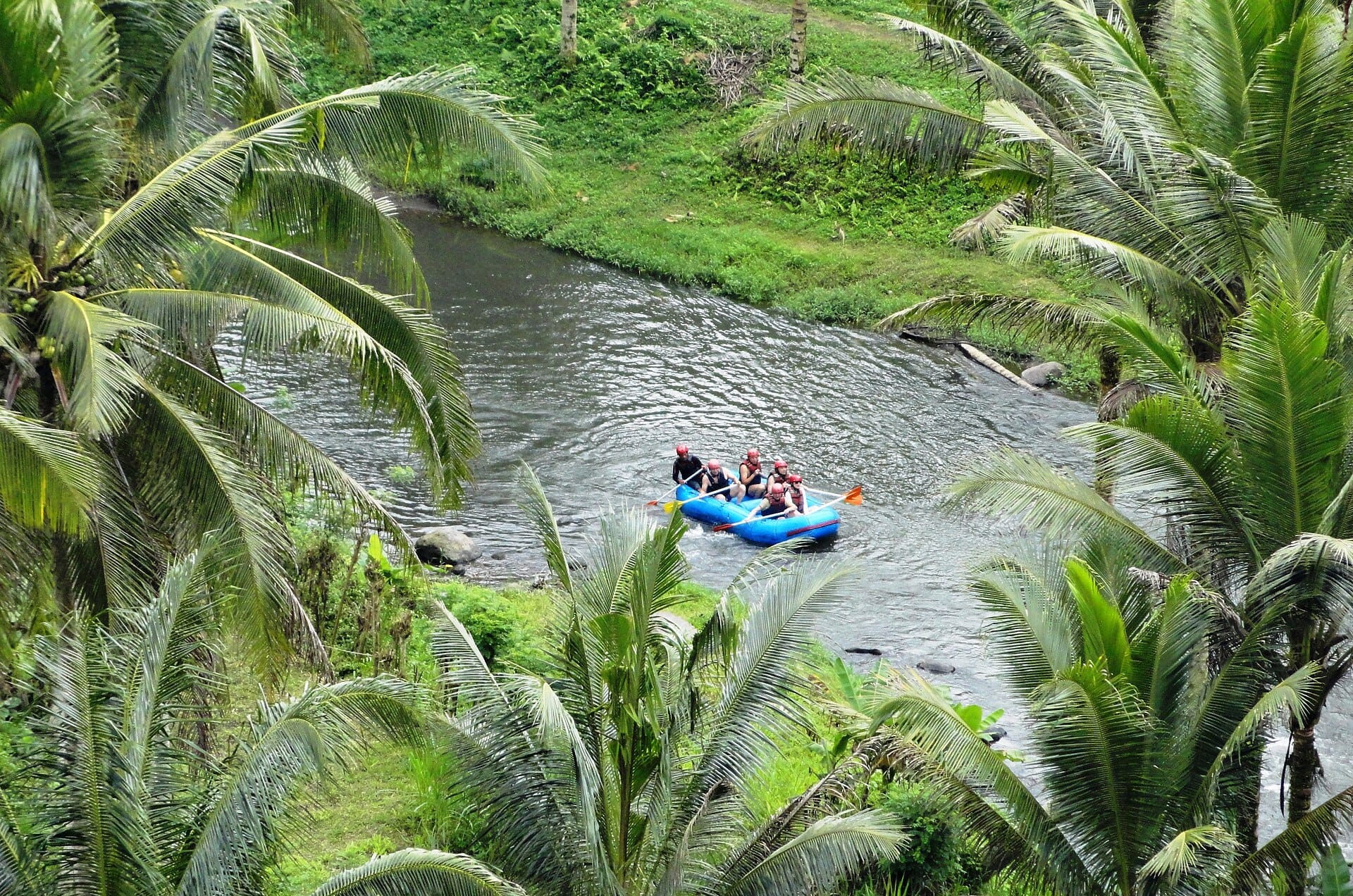 Rafters affrontano le dolci rapide del fiume Ayung tra la fitta foresta pluviale di Bali, gole spettacolari e bassorilievi lungo le pareti rocciose vicino a Ubud.