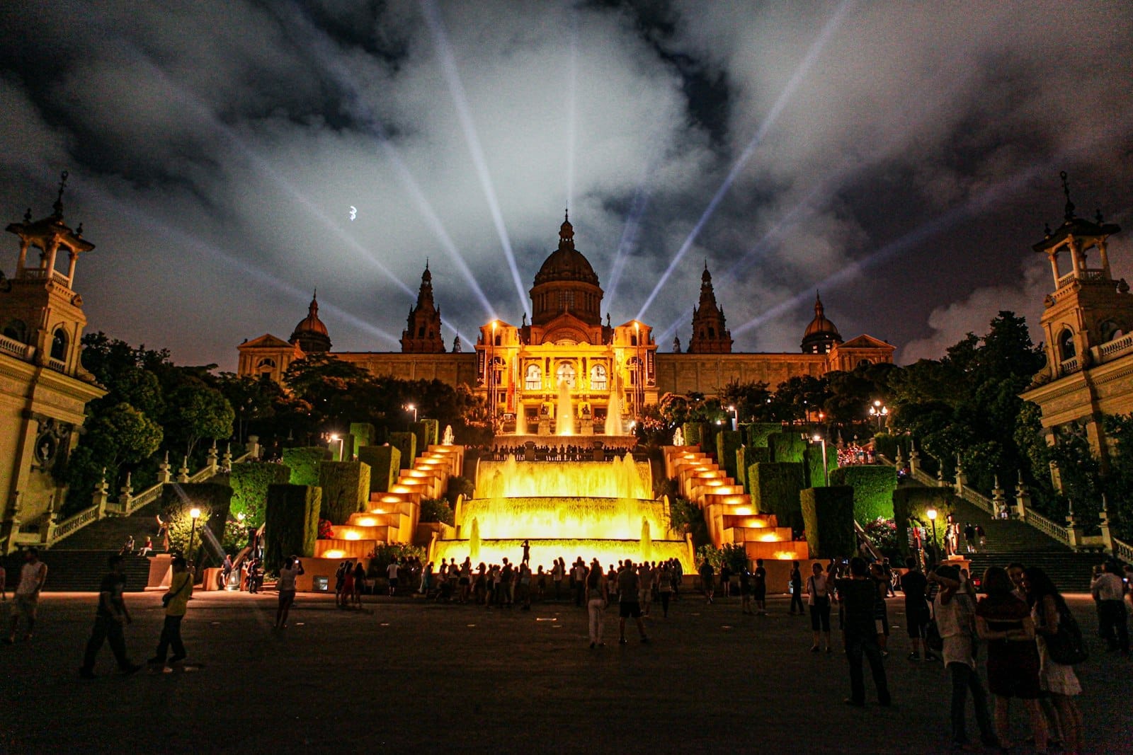 Night view of Barcelona's Palau Nacional on Montjuïc with illuminated fountains and crowds in front