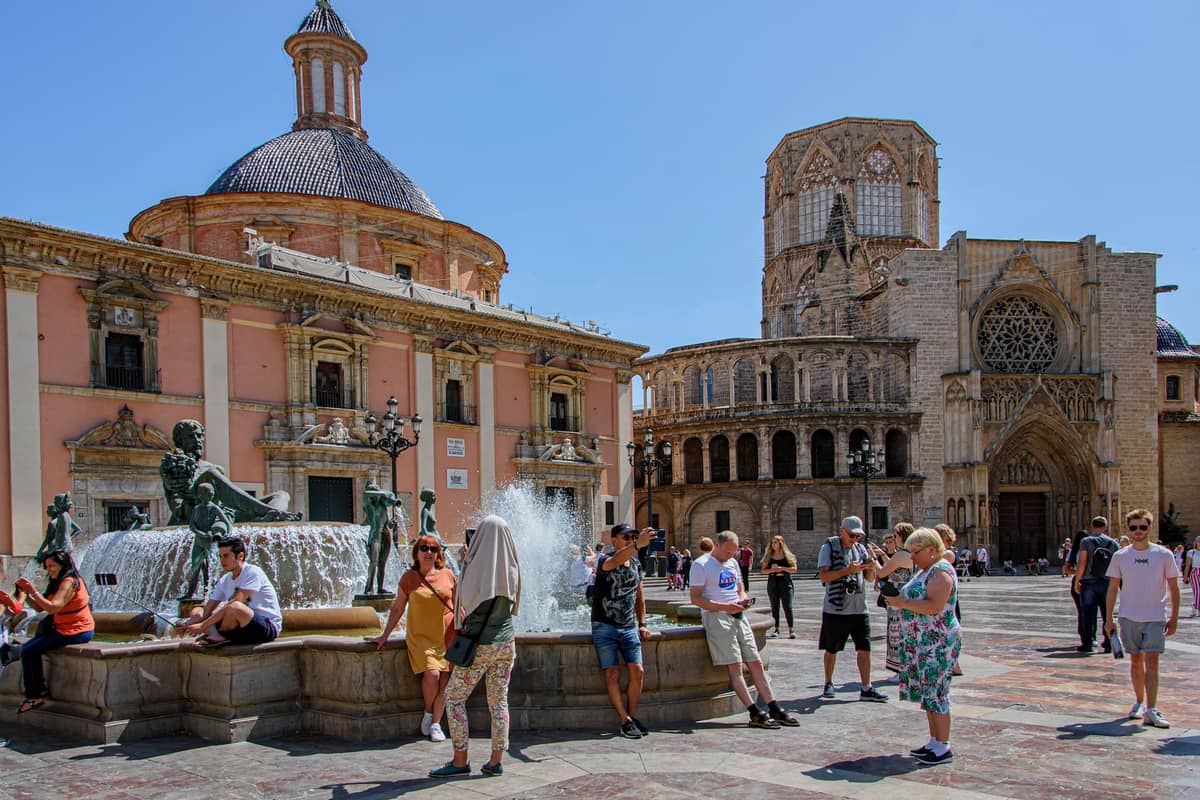 La Basílica de la Virgen de los Desamparados con la sua cupola sulla Plaça de la Verge, con i visitatori attorno alla fontana centrale, Valencia.
