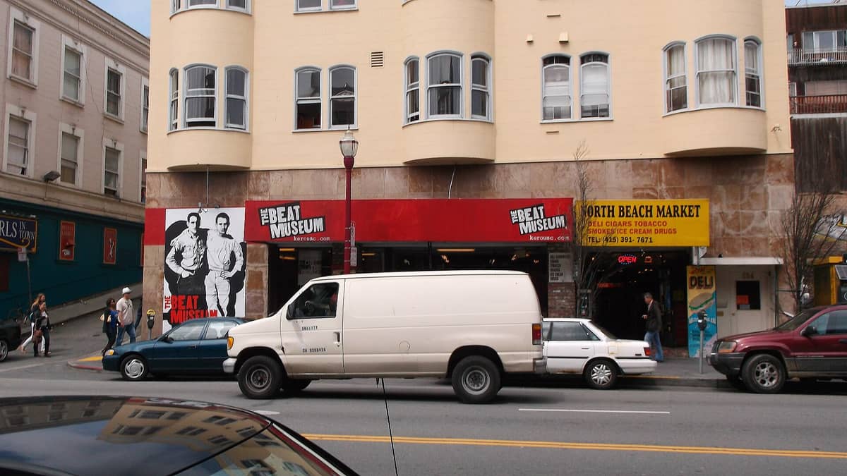 Vista esterna del Beat Museum a San Francisco: la tenda rossa, il grande murales e l'ingresso su Broadway a North Beach.
