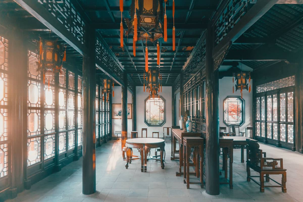 Elegantes Interieur eines traditionellen chinesischen Hofhauses mit klassischen Holzmöbeln und verzierten Fenstern im Stil eines Boutique-Hotels in Beijing.