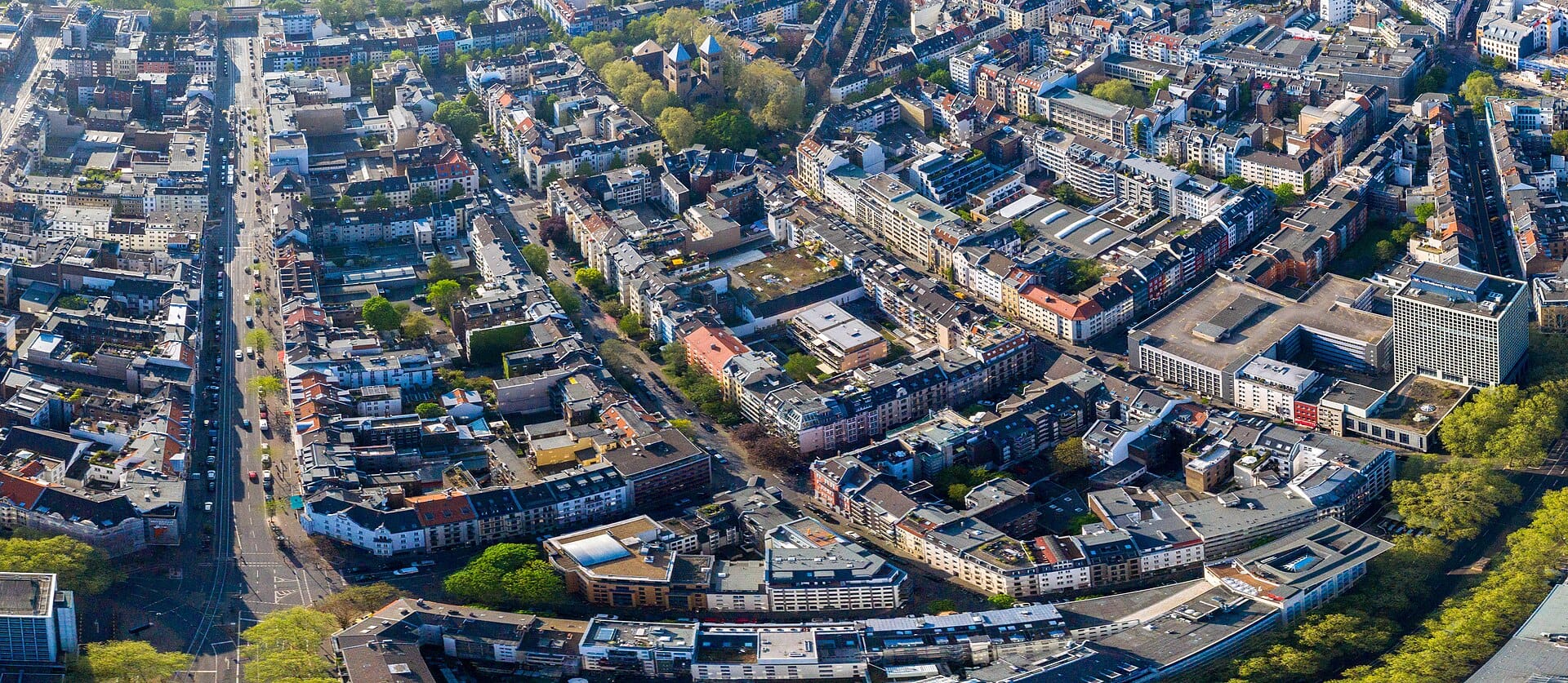ภาพถ่ายมุมสูงของย่าน Belgian Quarter เมืองโคโลญ เห็นถนนเป็นตาราง ตึกเก่าแก่และพื้นที่สีเขียว สะท้อนโครงสร้างเมืองอันเป็นเอกลักษณ์