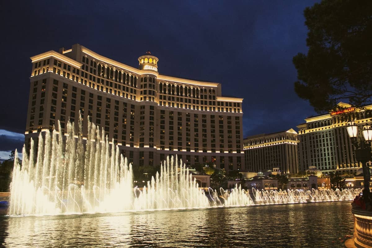 โรงแรม Bellagio สว่างไสวในยามค่ำคืน พร้อมน้ำพุอันโด่งดังที่พุ่งสูงเหนือทะเลสาบระยิบระยับบน Las Vegas Strip