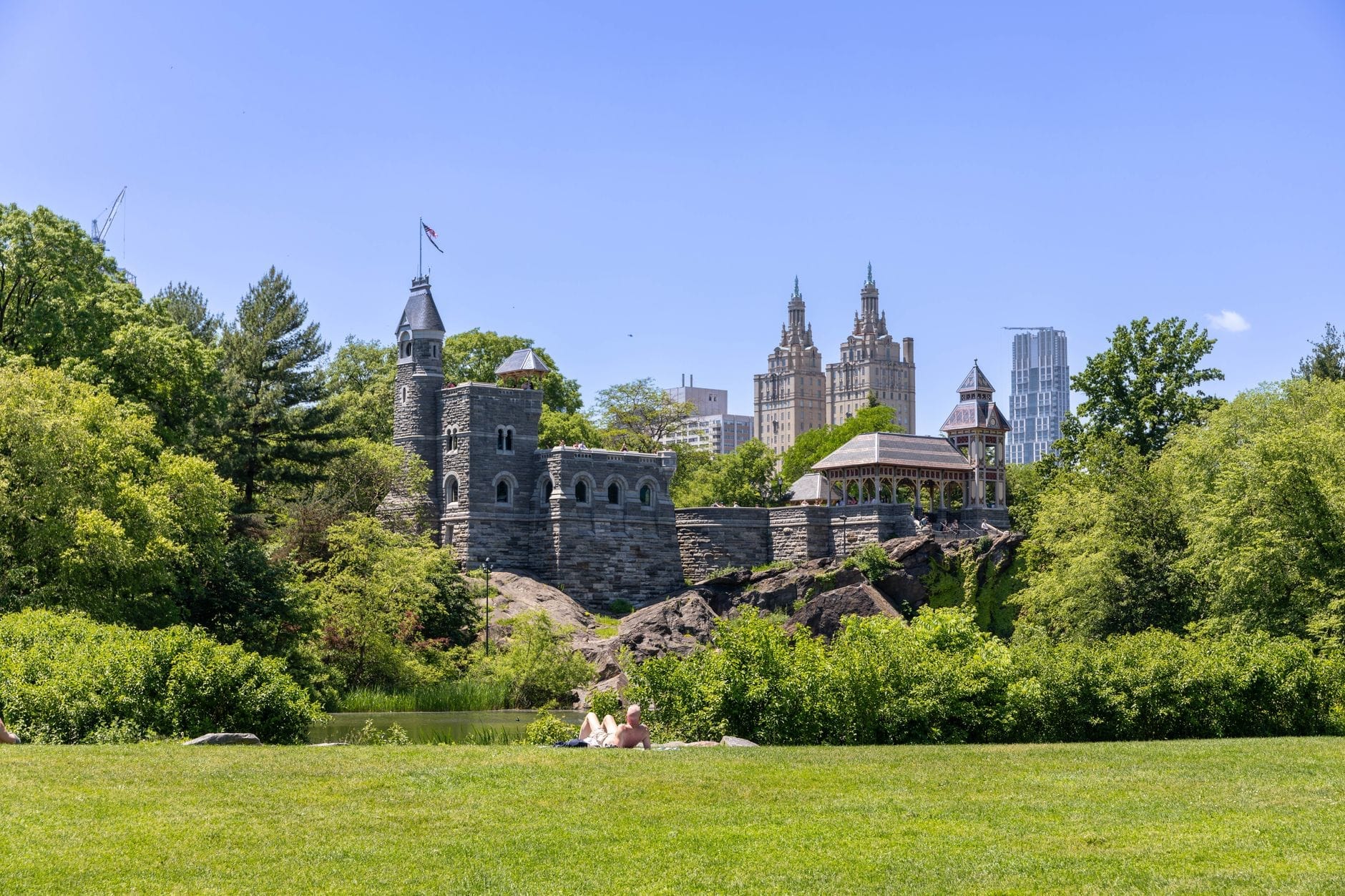 Il Castello del Belvedere in cima a una collina rocciosa di Central Park, circondato dal verde e dai grattacieli di Manhattan in una giornata di sole.