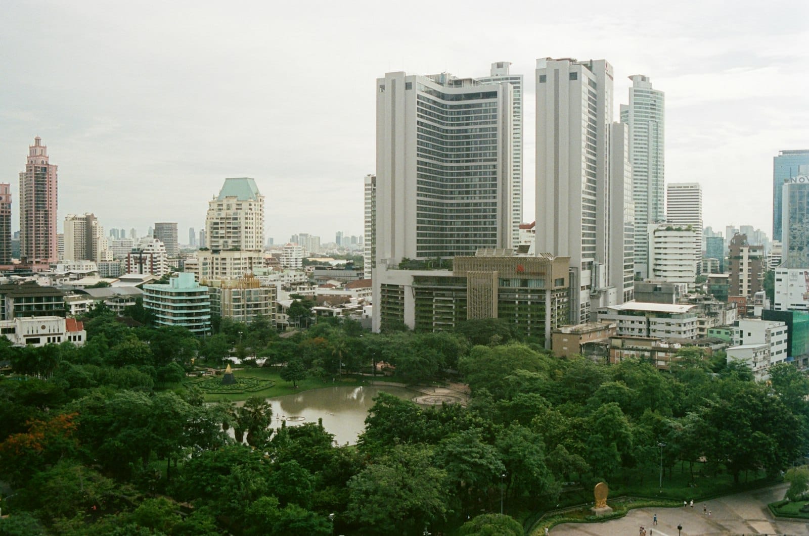 Benchasiri Park a Sukhumvit con lago, prati verdi e skyline di Bangkok sullo sfondo vicino a Phrom Phong