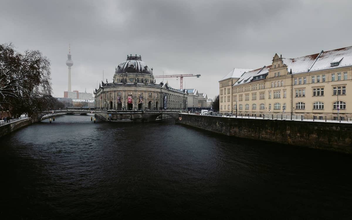 Vista invernale dell'Isola dei Musei di Berlino con il Bode-Museum, neve sui tetti e cielo coperto