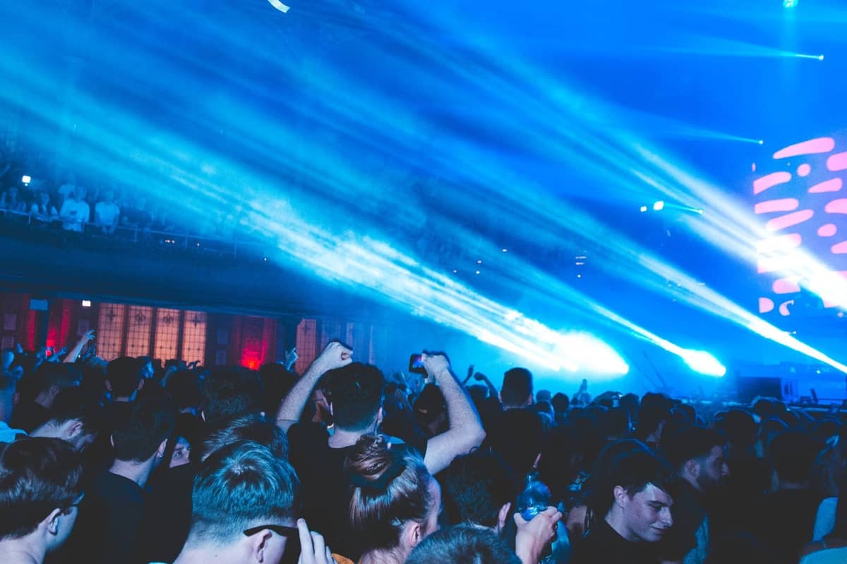 Überfüllter Berliner Nachtclub mit blauen Bühnenlichtern, energetischer Menge und lebhafter Nachtleben-Atmosphäre