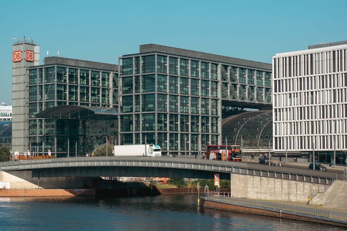 Fachada de cristal moderna del Berlin Hauptbahnhof con puente adyacente y río en un día despejado