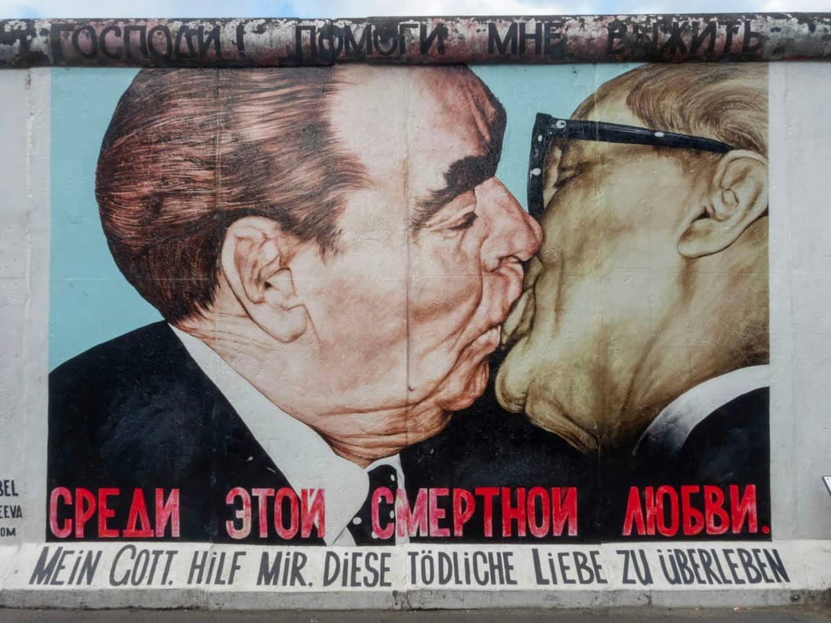 Ikonisches Wandbild der Berliner Mauer mit dem berühmten sozialistischen Bruderkuss zwischen Breschnew und Honecker, ein Symbol der Geschichte der Teilung im Kalten Krieg.