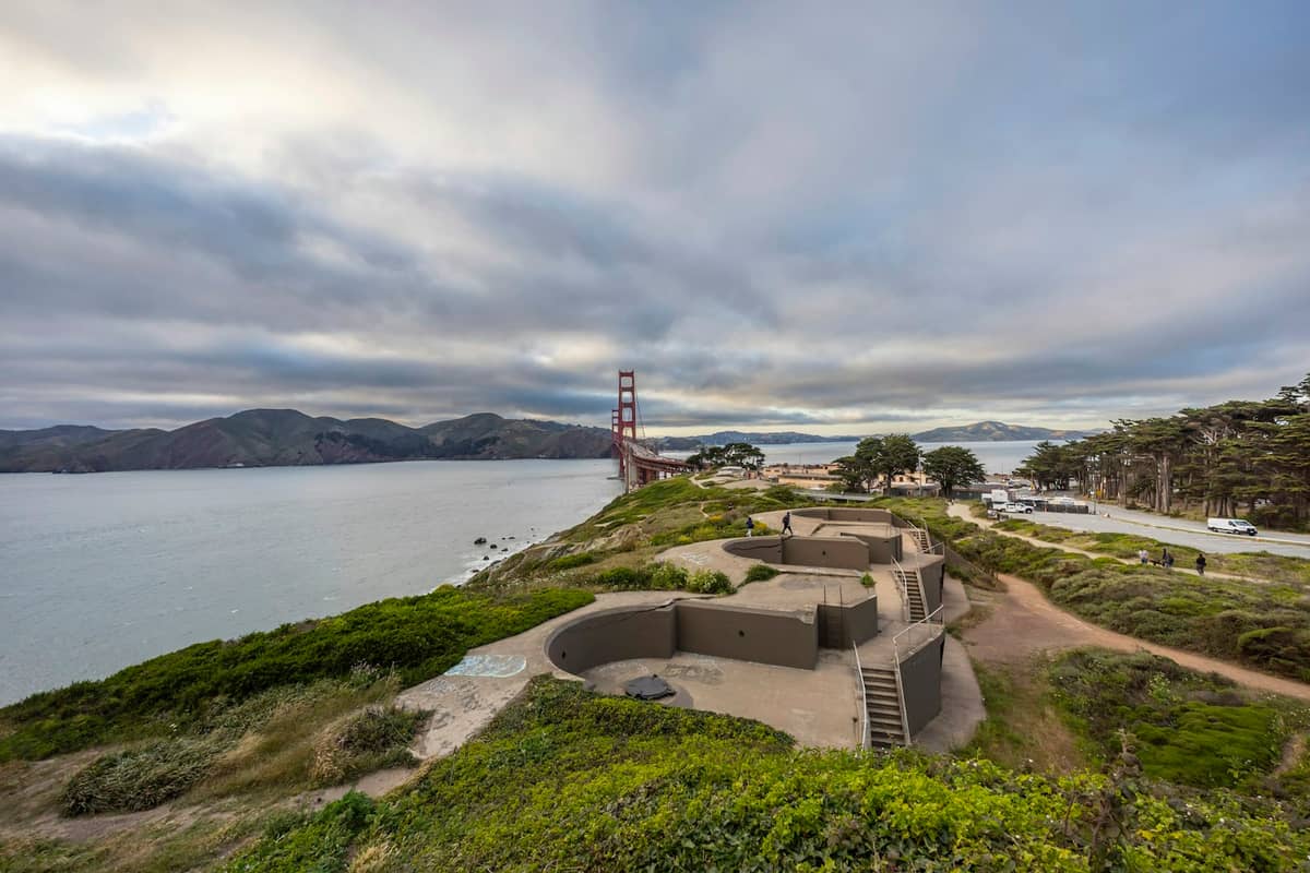 Suggestive rovine di una batteria costiera su una scogliera vicino al Golden Gate Bridge, con vista sull'acqua, sentieri panoramici e cielo nuvoloso.