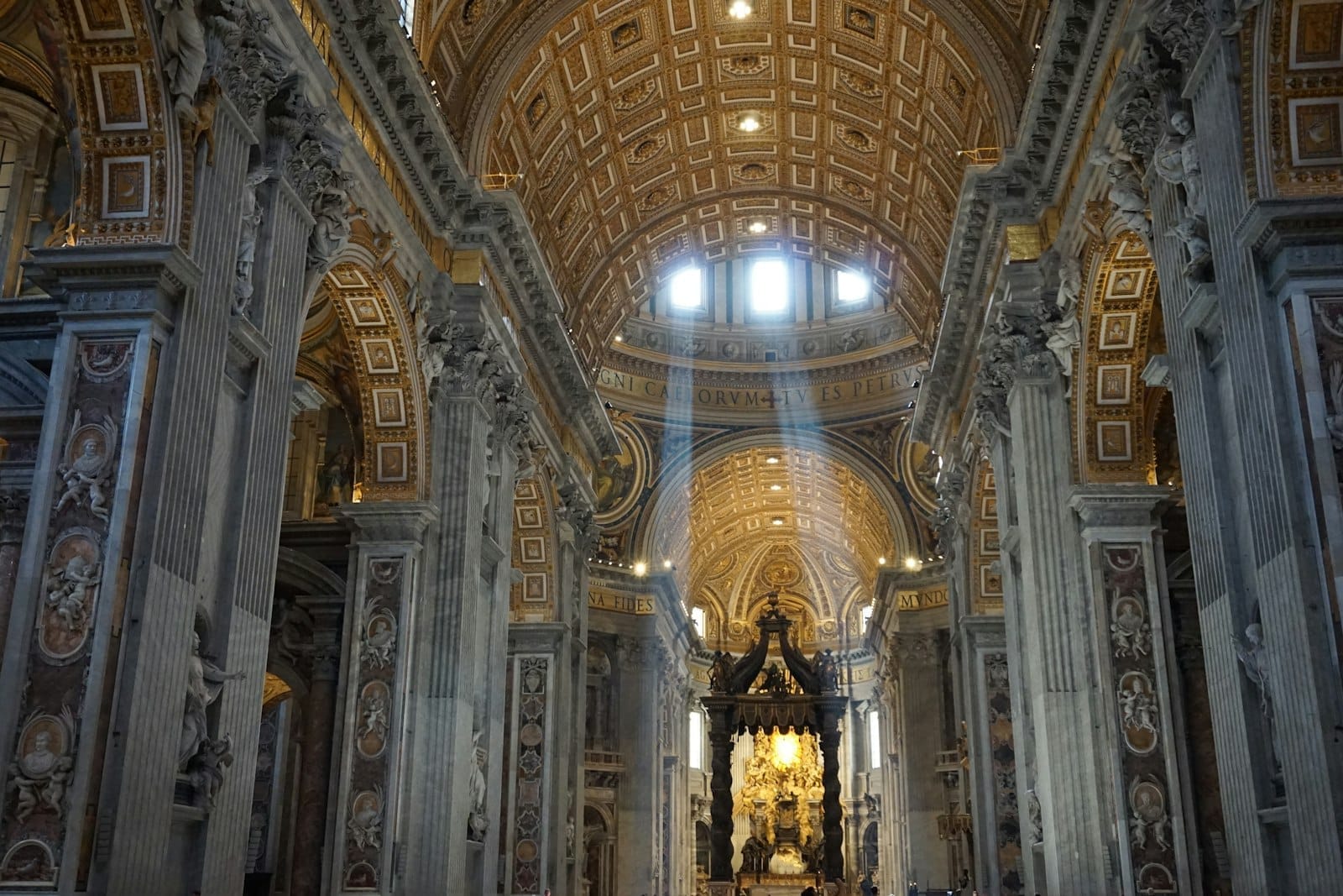 Sunlight streams through the grand gilded dome and ornate arches of a majestic basilica interior in Rome, showcasing stunning architecture and sacred atmosphere.