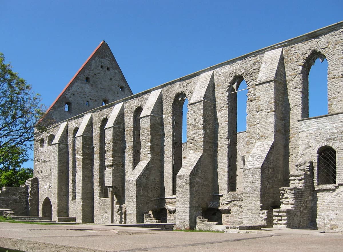 Ruinas del Convento de Santa Brígida con altas paredes de piedra y ventanas arqueadas, abiertas al cielo azul cerca de Tallinn.