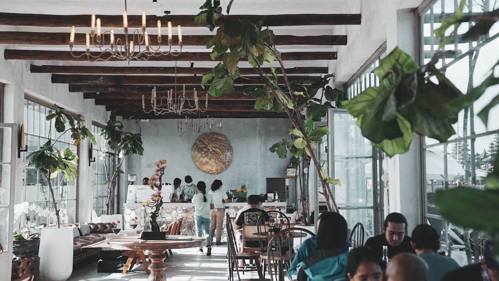 Intérieur de café animé à Bali avec voyageurs et plantes tropicales