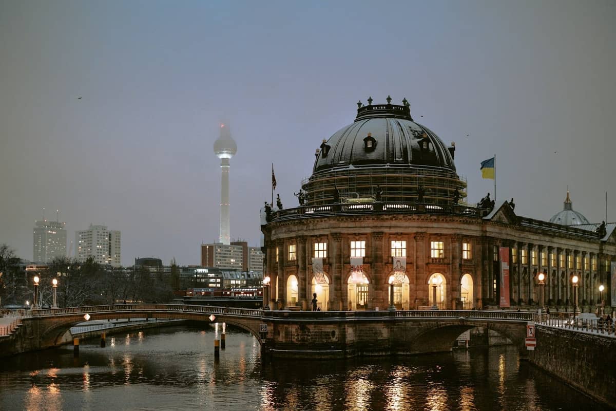 Abendliche Ansicht des Bode-Museums in Berlin an der Spree, mit dem Fernsehturm im Hintergrund.