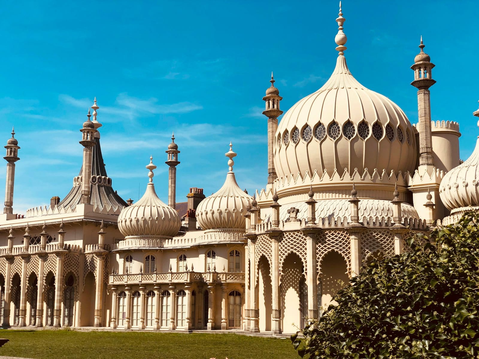 Die ikonischen Kuppeln und Türme des Royal Pavilion in Brighton unter einem klaren blauen Himmel.