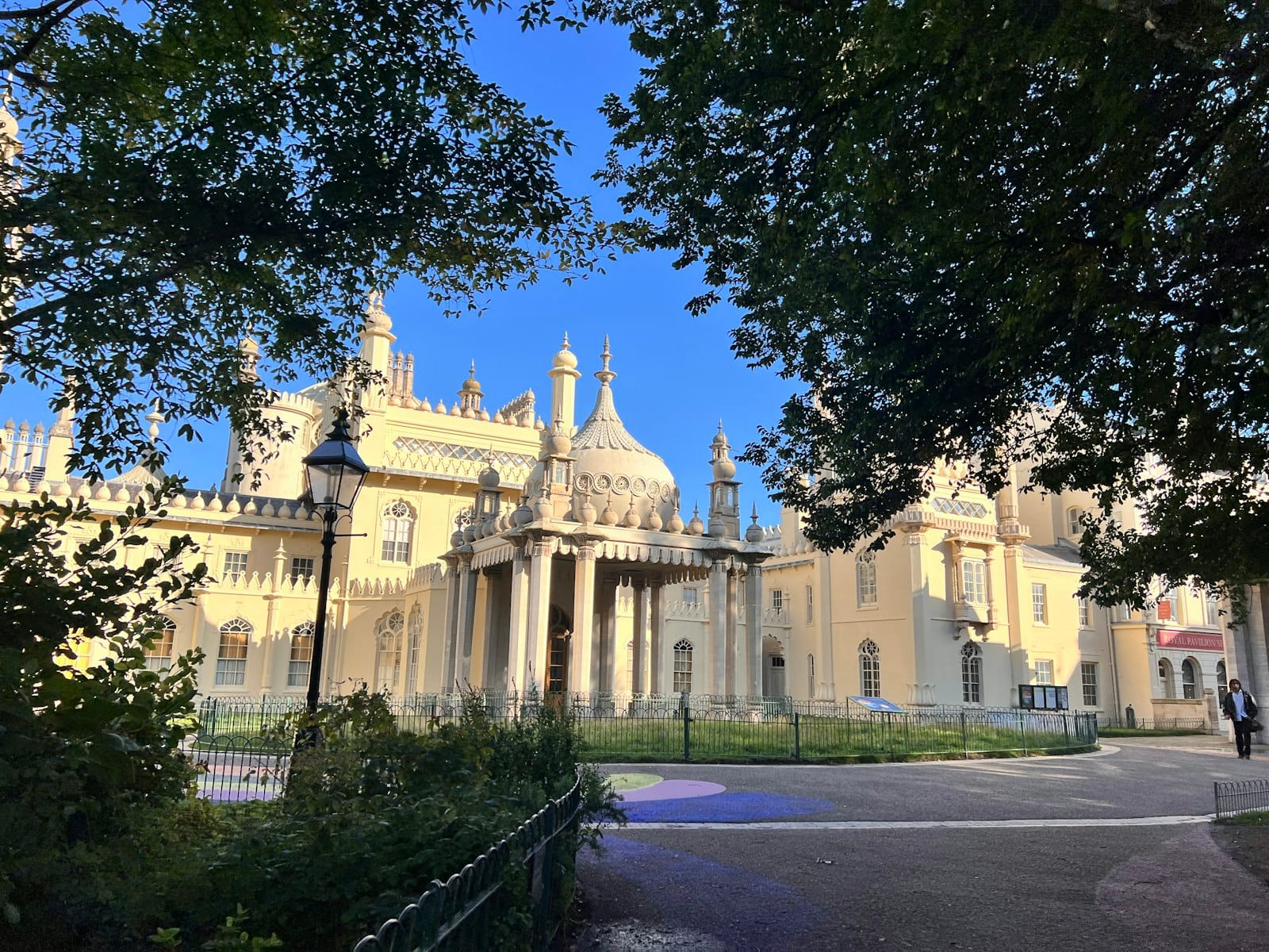 Blick auf den Royal Pavilion in Brighton, umrahmt von Bäumen, mit verzierter Architektur und sonnigem Himmel