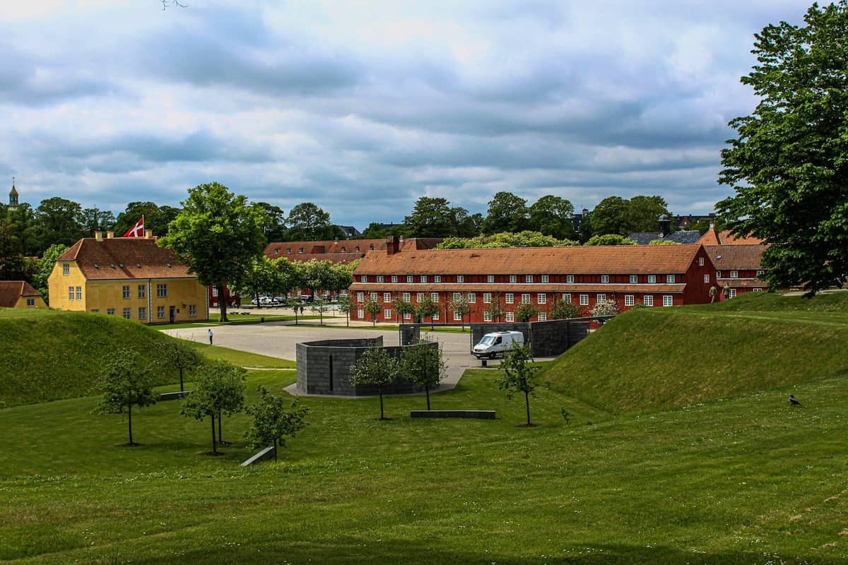 Widok na Muzeum Duńskiego Ruchu Oporu i historyczne budynki w Kastellet w Kopenhadze w słoneczny dzień z zielonymi trawnikami na pierwszym planie