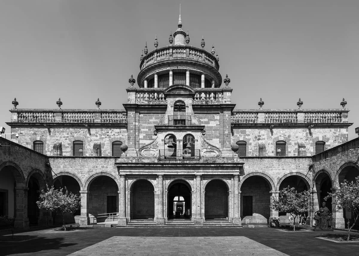 ภาพขาวดำของ Hospicio Cabañas อาคารนีโอคลาสสิกทางประวัติศาสตร์และแหล่งมรดกโลก UNESCO ในเมือง Guadalajara พร้อมโดมขนาดใหญ่และทางเข้าโค้งอาร์ช